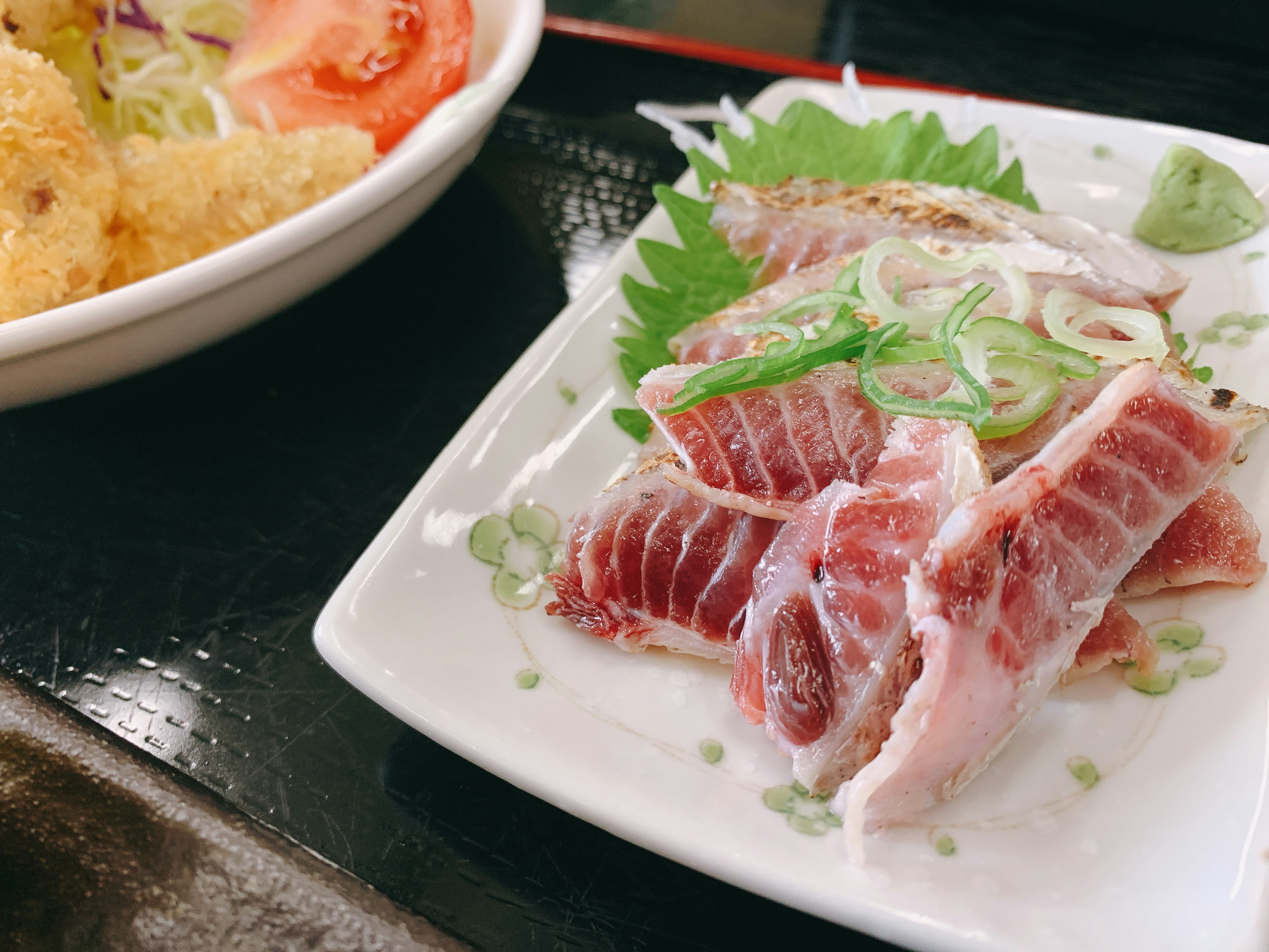 Assiette de sashimi frais avec des oignons verts et des garnitures