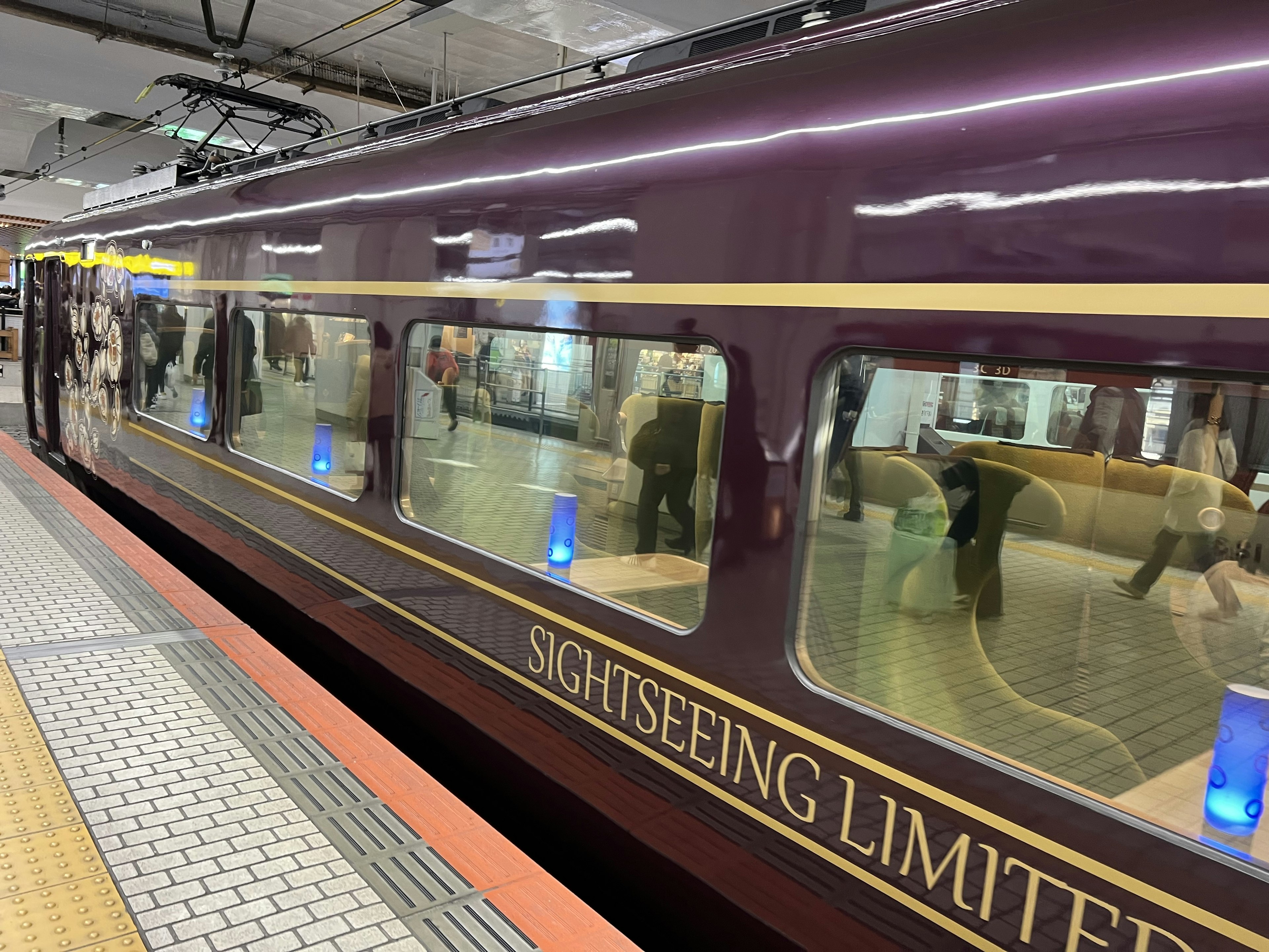 Train touristique limité violet garé à une station