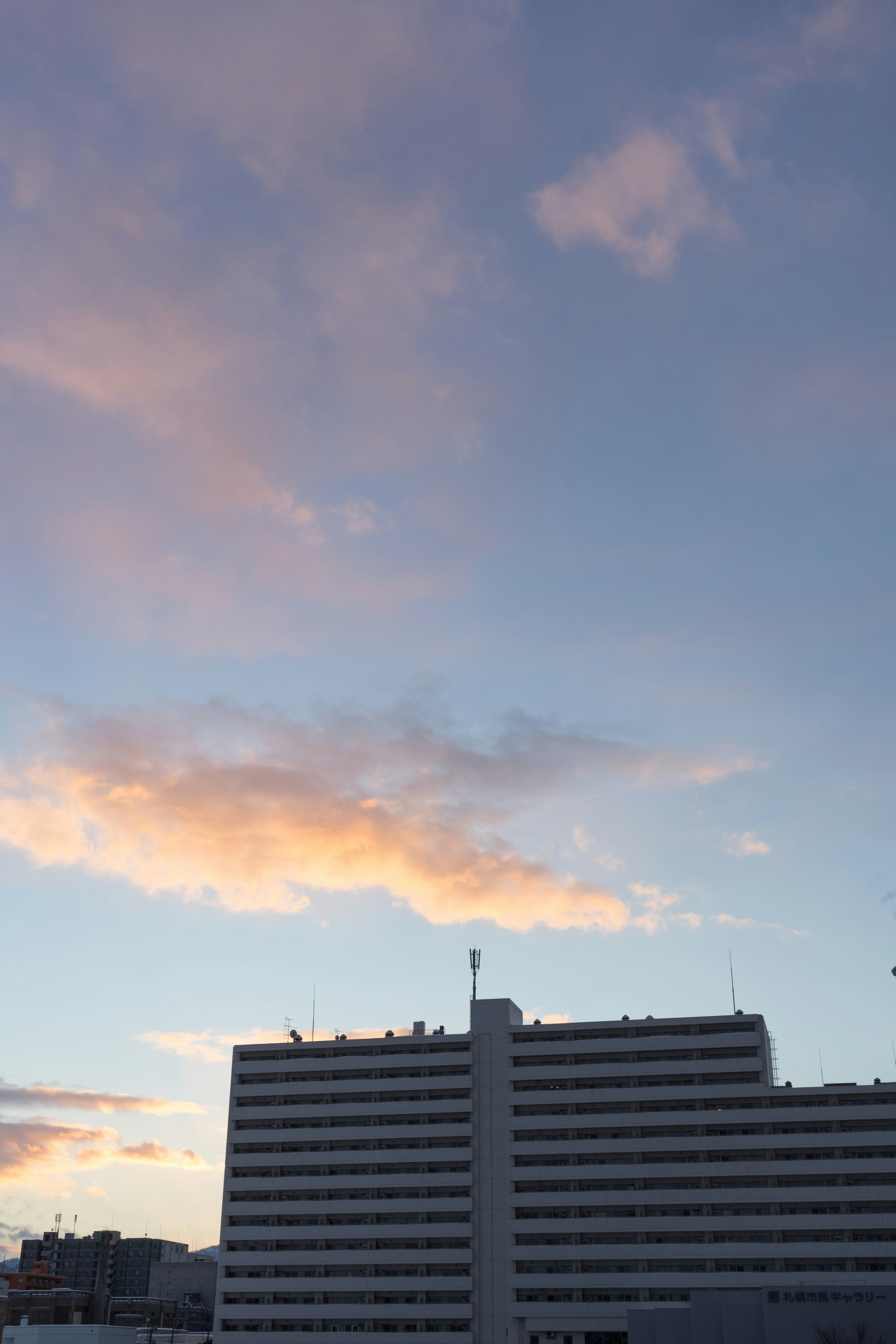 夕焼けの空と白いビルのシルエット