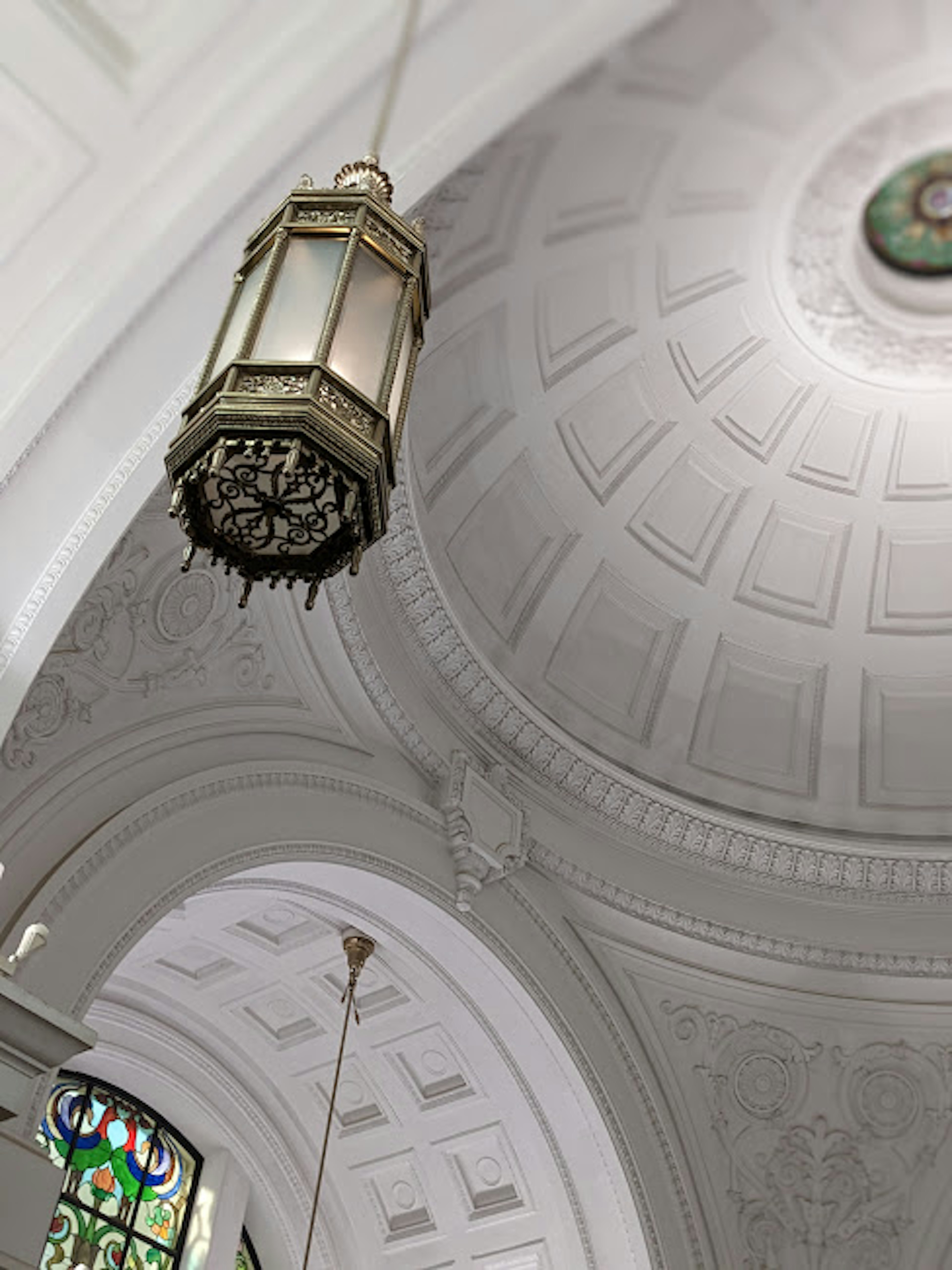 Pemandangan interior gereja dengan langit-langit yang dihias dan lentera yang tergantung