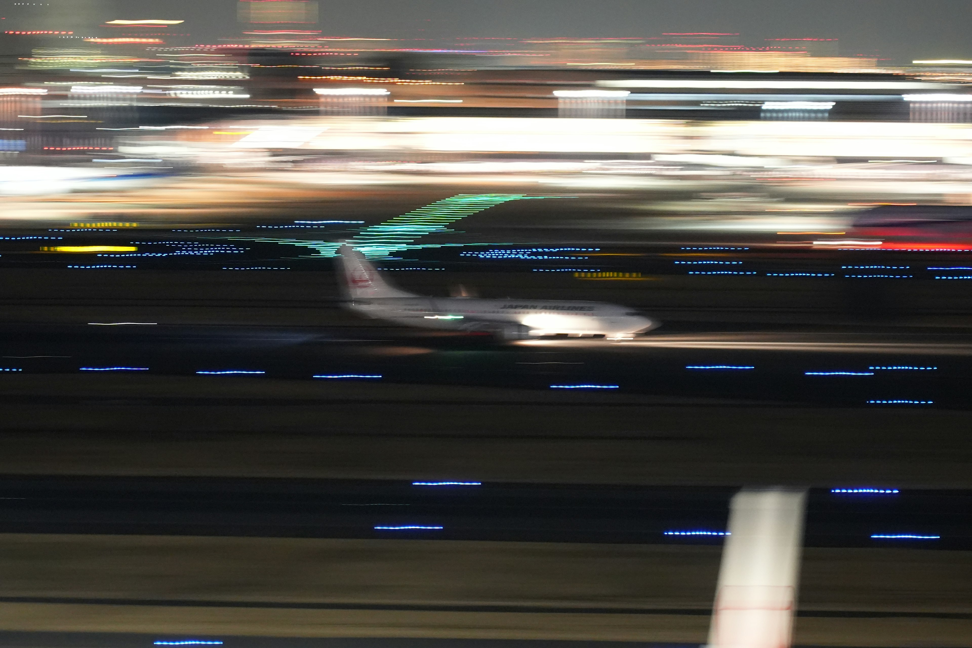 Una escena nocturna borrosa de un avión despegando en una pista