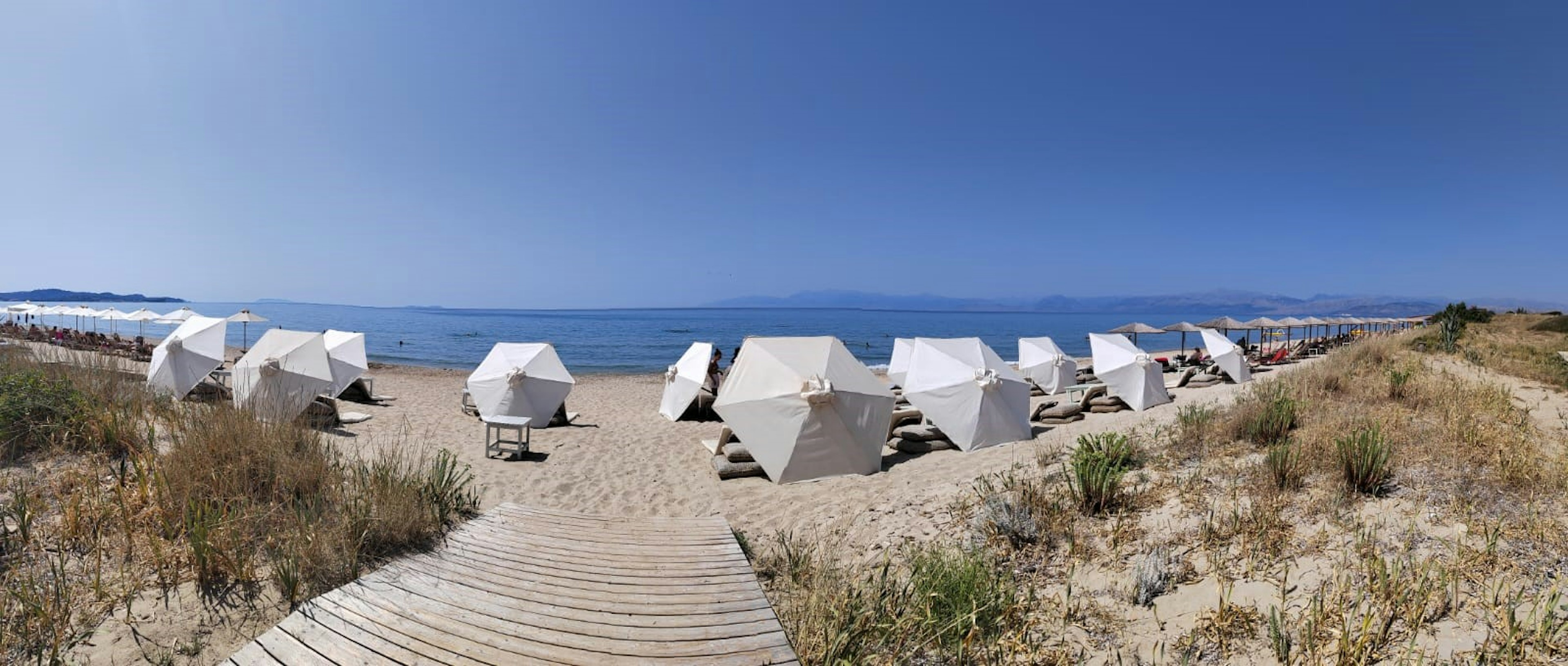 Scène de plage avec des parasols blancs et un océan bleu