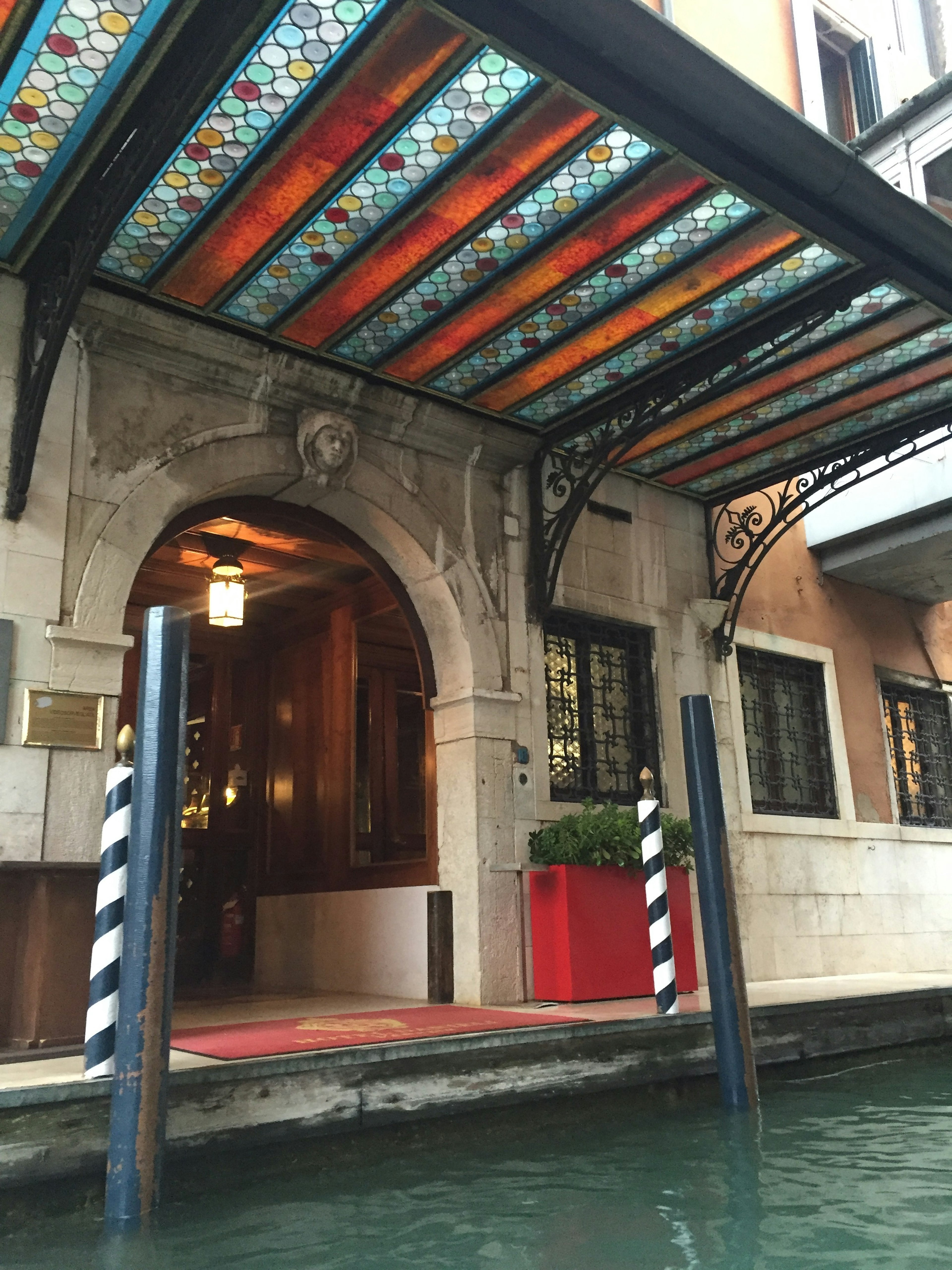 Hermosa entrada en arco de un edificio junto al canal con techo colorido