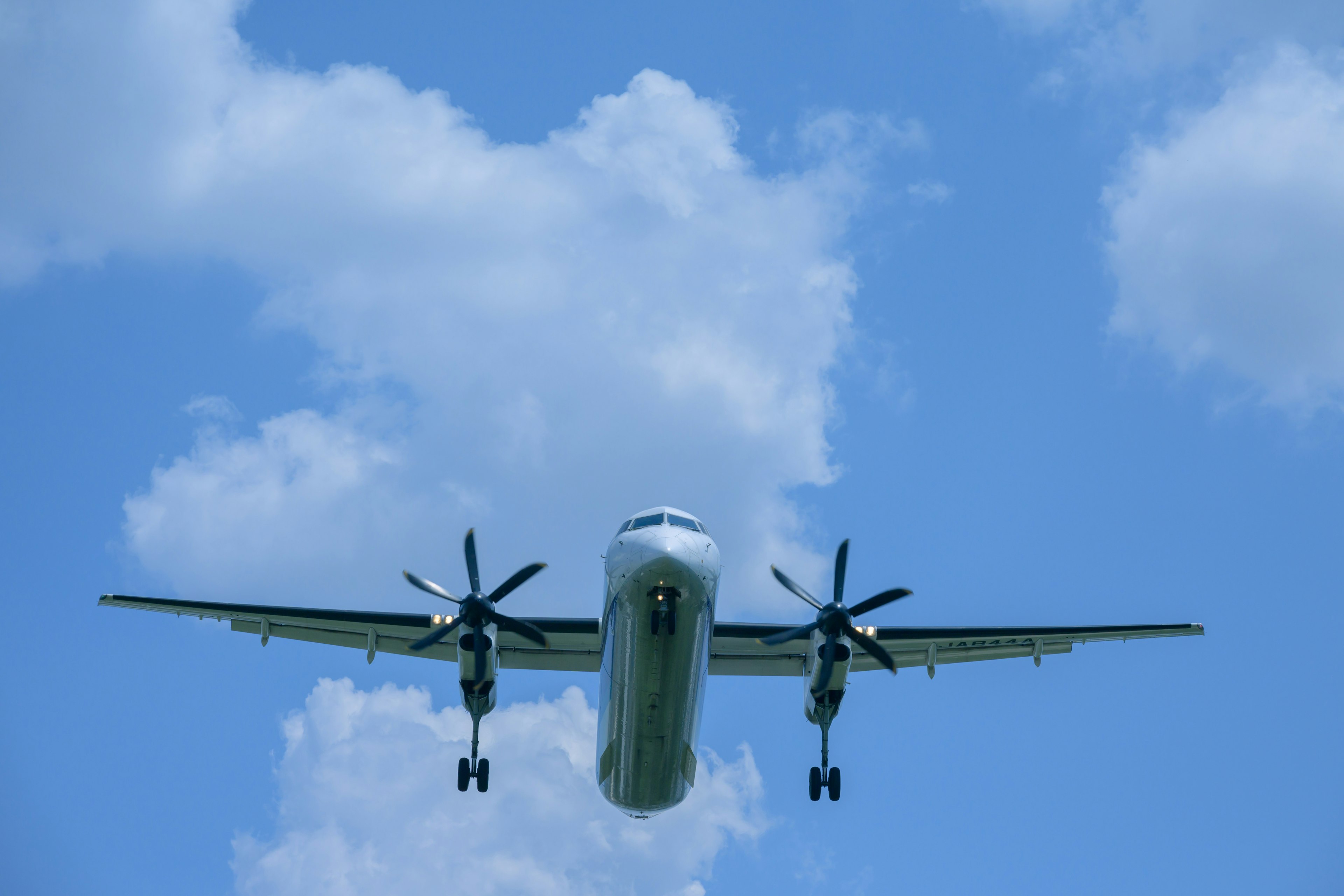 Propellerflugzeug fliegt gegen einen blauen Himmel aus niedriger Perspektive