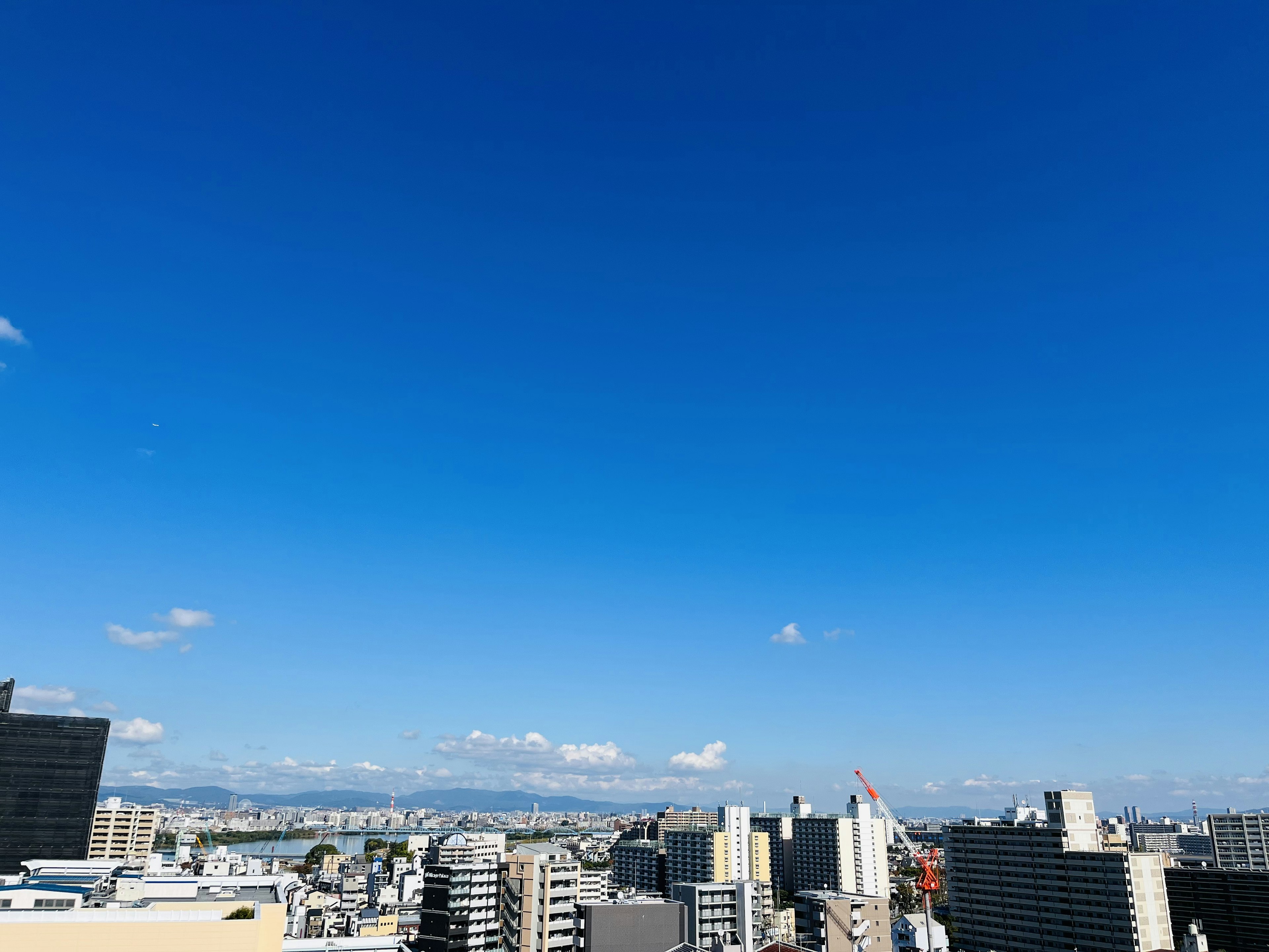 Immagine che mostra un cielo blu chiaro su uno skyline urbano