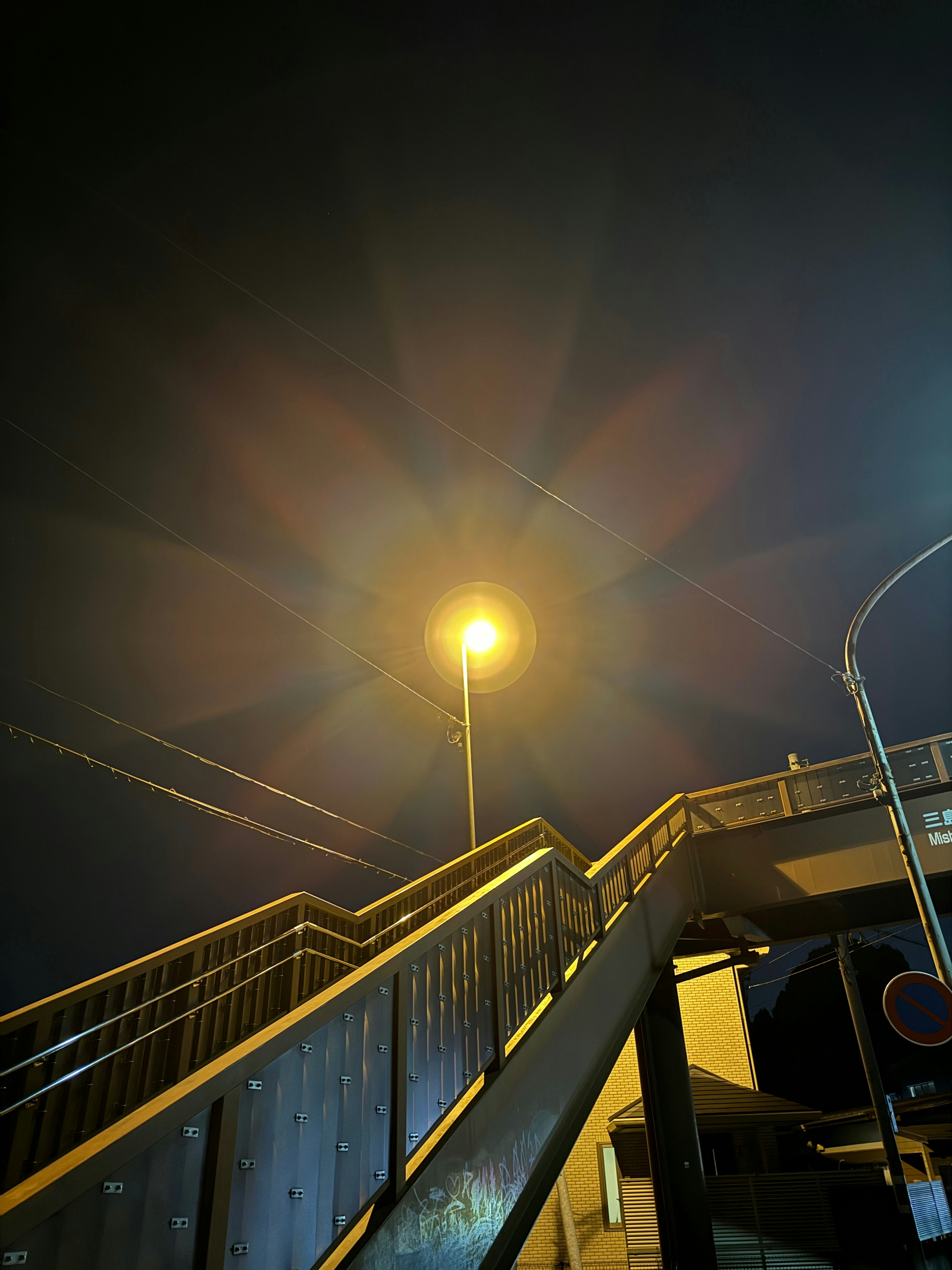 Night scene featuring a staircase and a bright streetlight