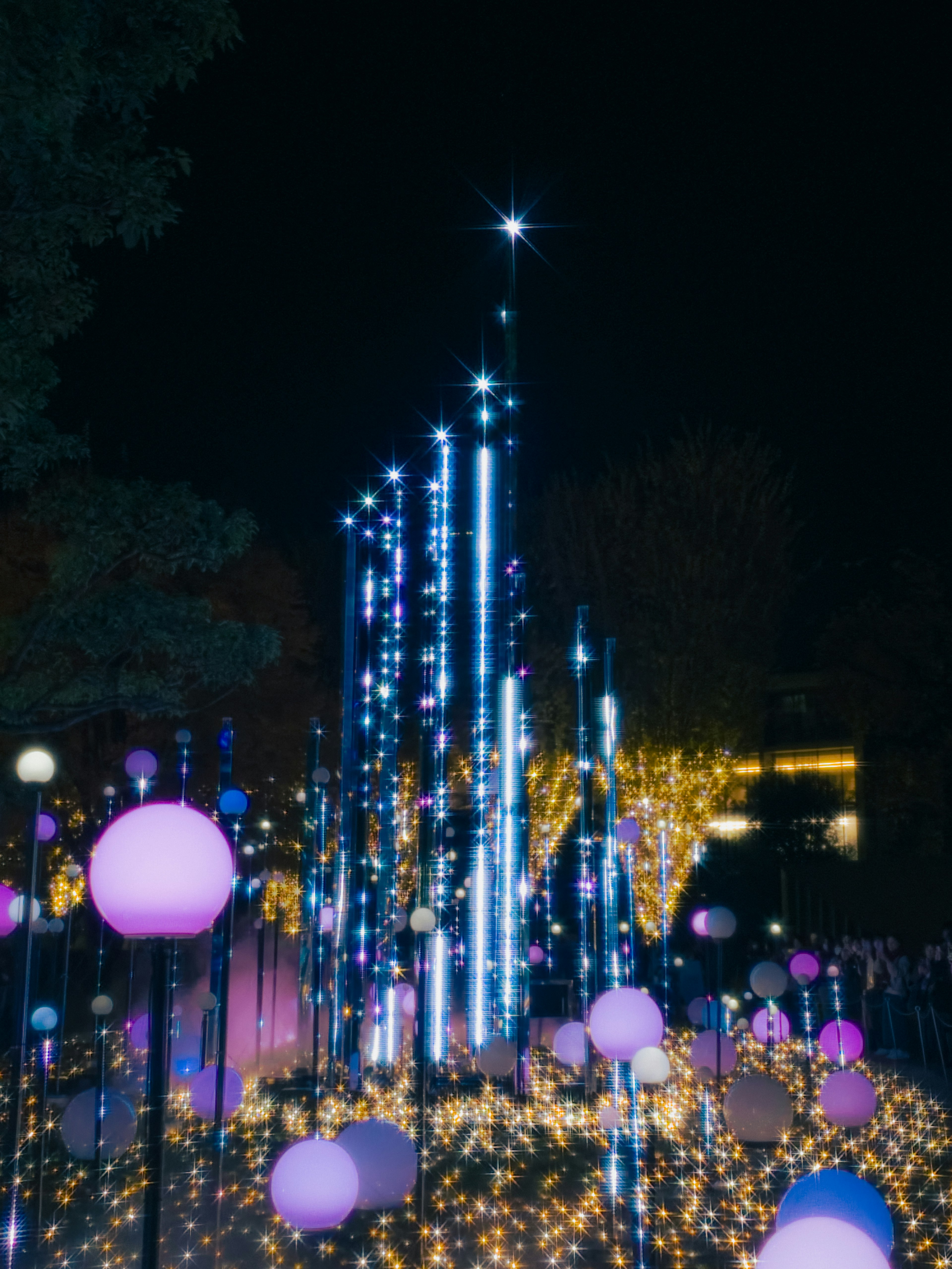 Nachts installierte Lichtinstallation mit leuchtenden blauen und lila Lichtern