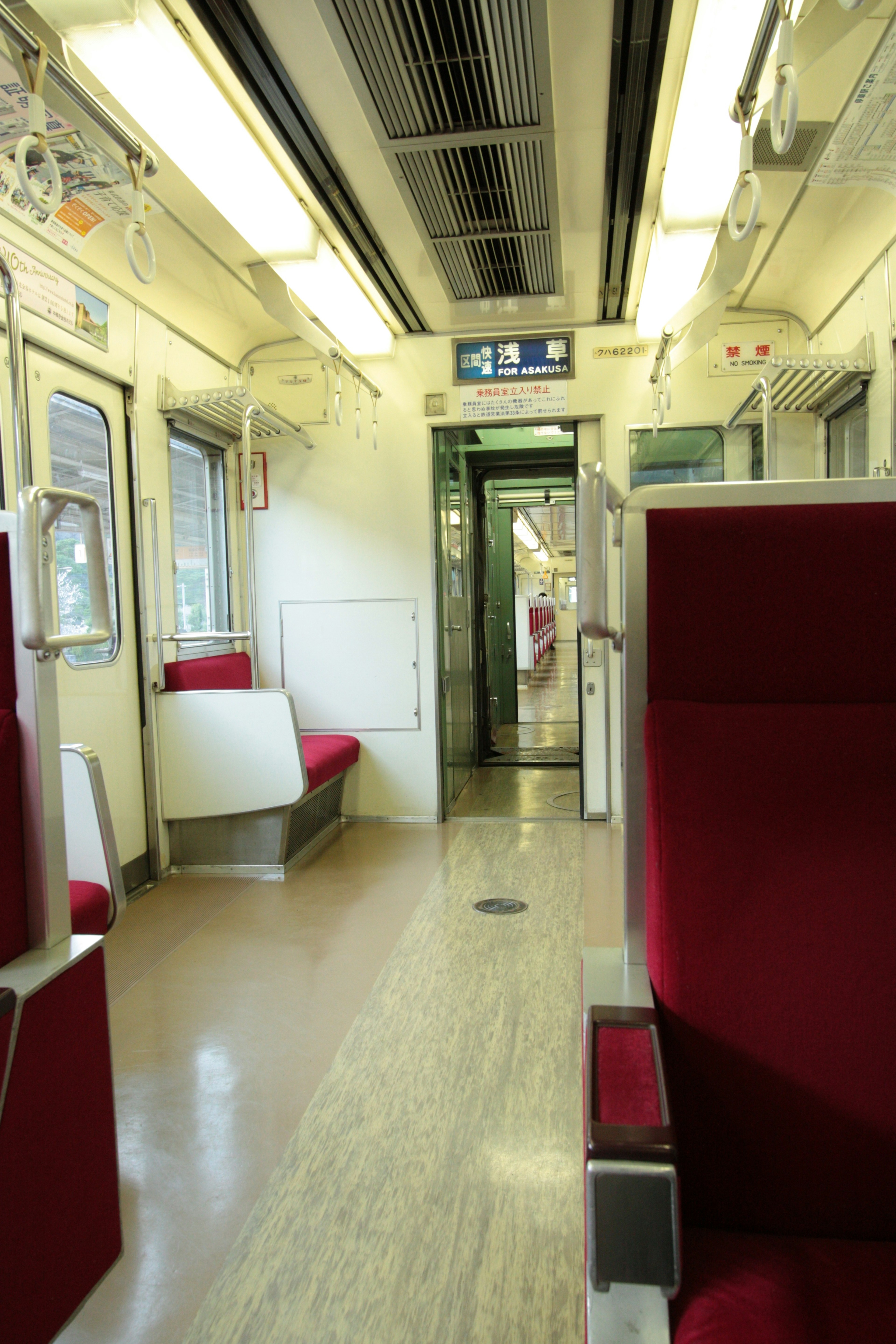 Vagone del treno tranquillo con sedili rossi e illuminazione brillante