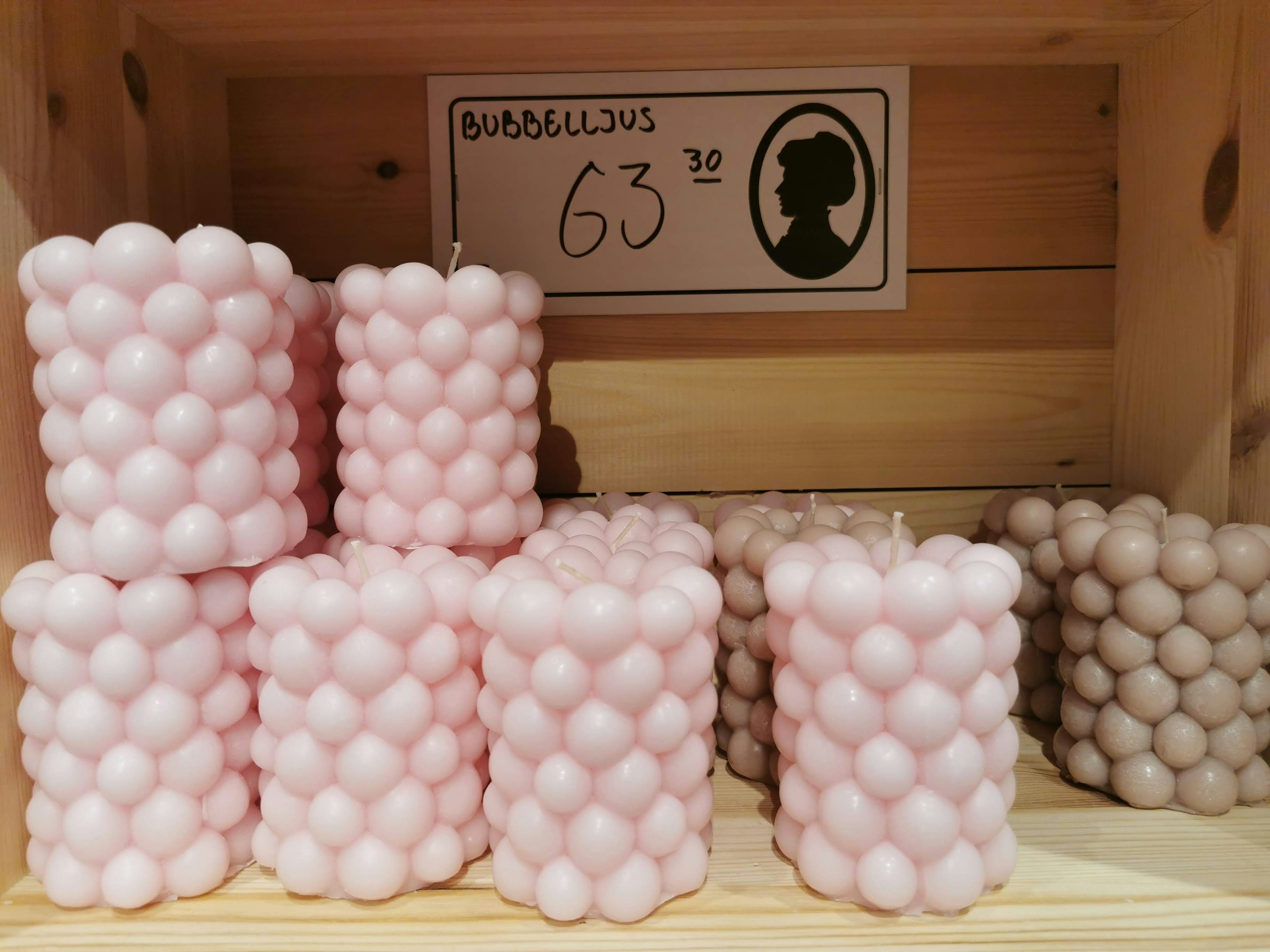 Candele rosa con un design rotondo disposte in una scatola di legno