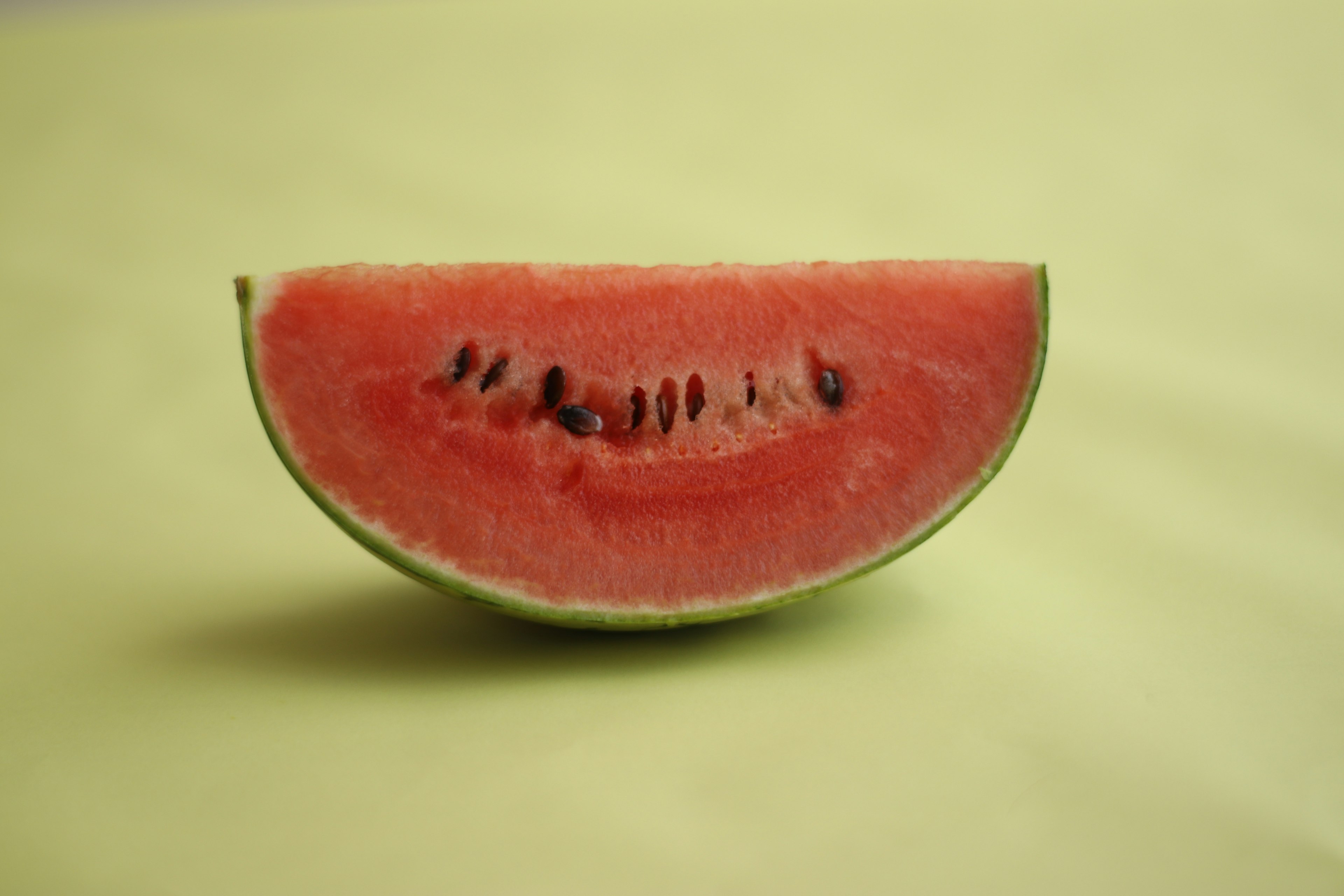 A half watermelon showing bright red flesh with black seeds