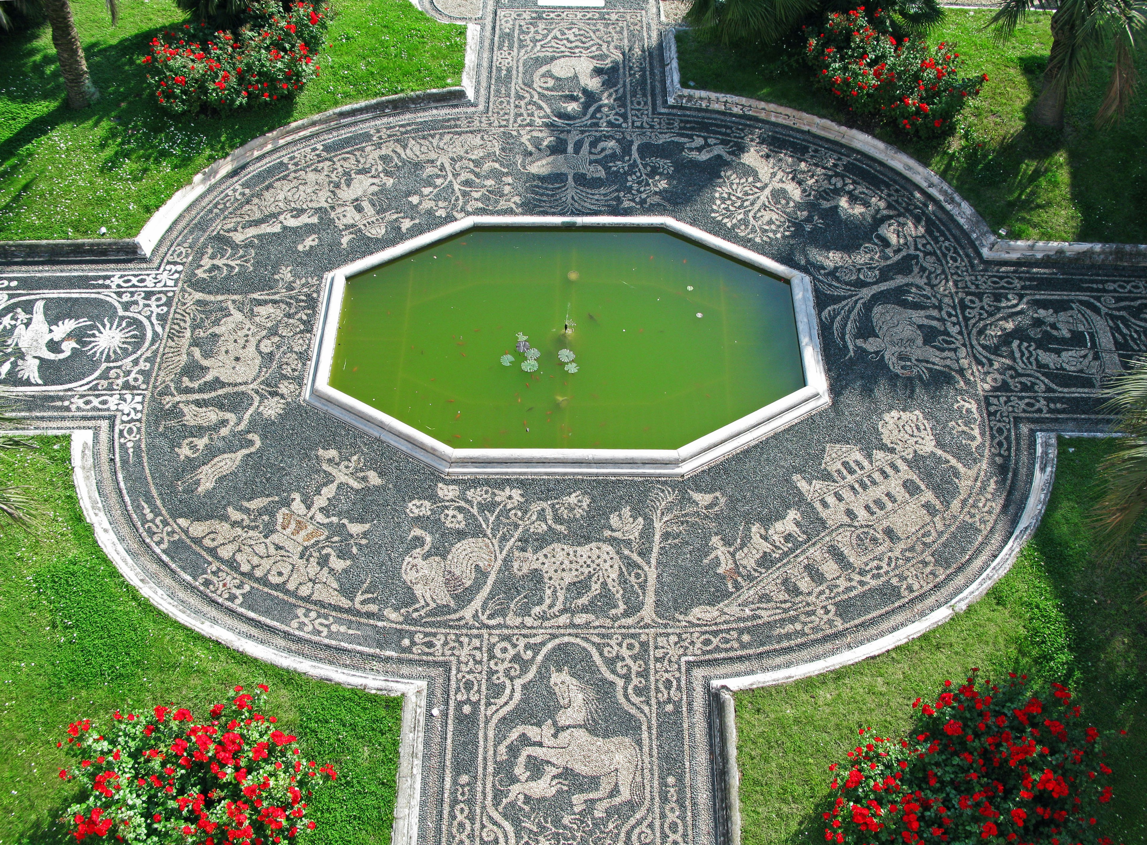 Garden design featuring a carved stone path surrounding a green pond