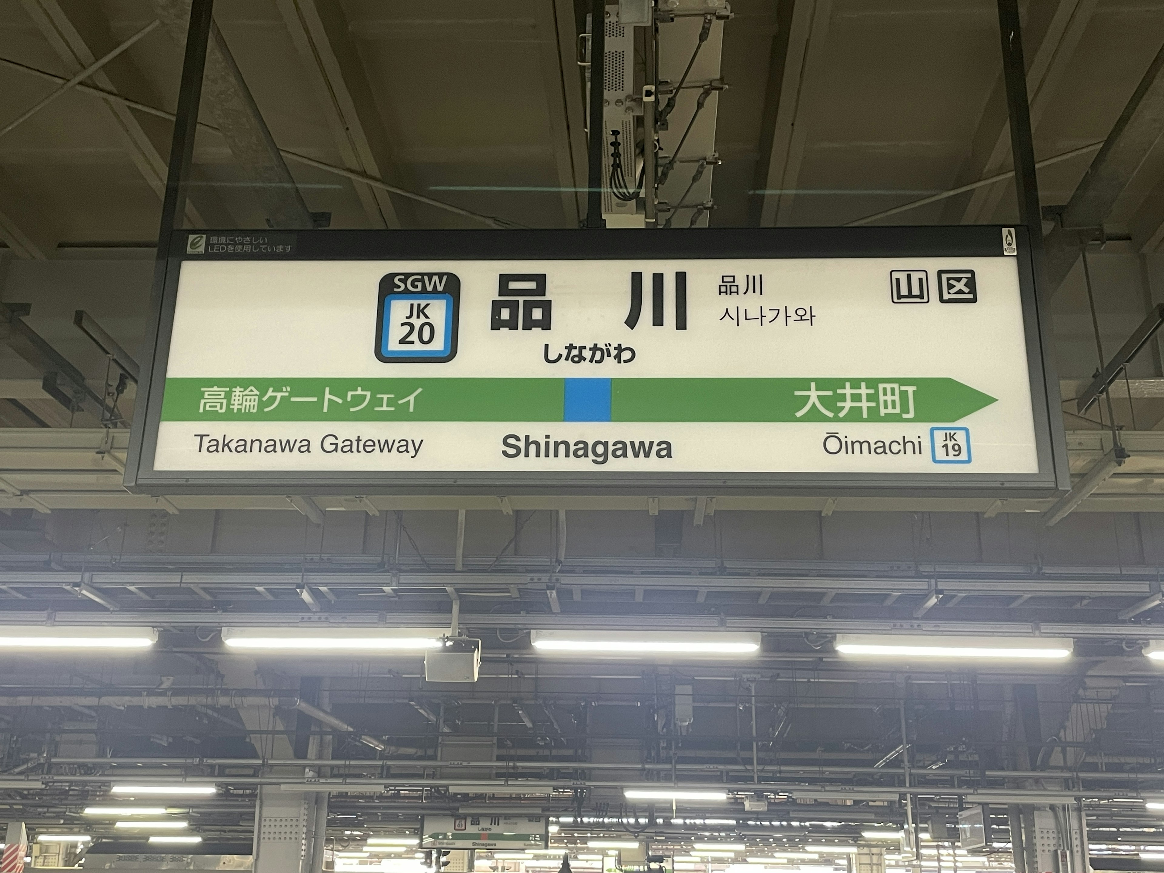 Panneau à la gare de Shinagawa affichant le nom de la gare et les directions