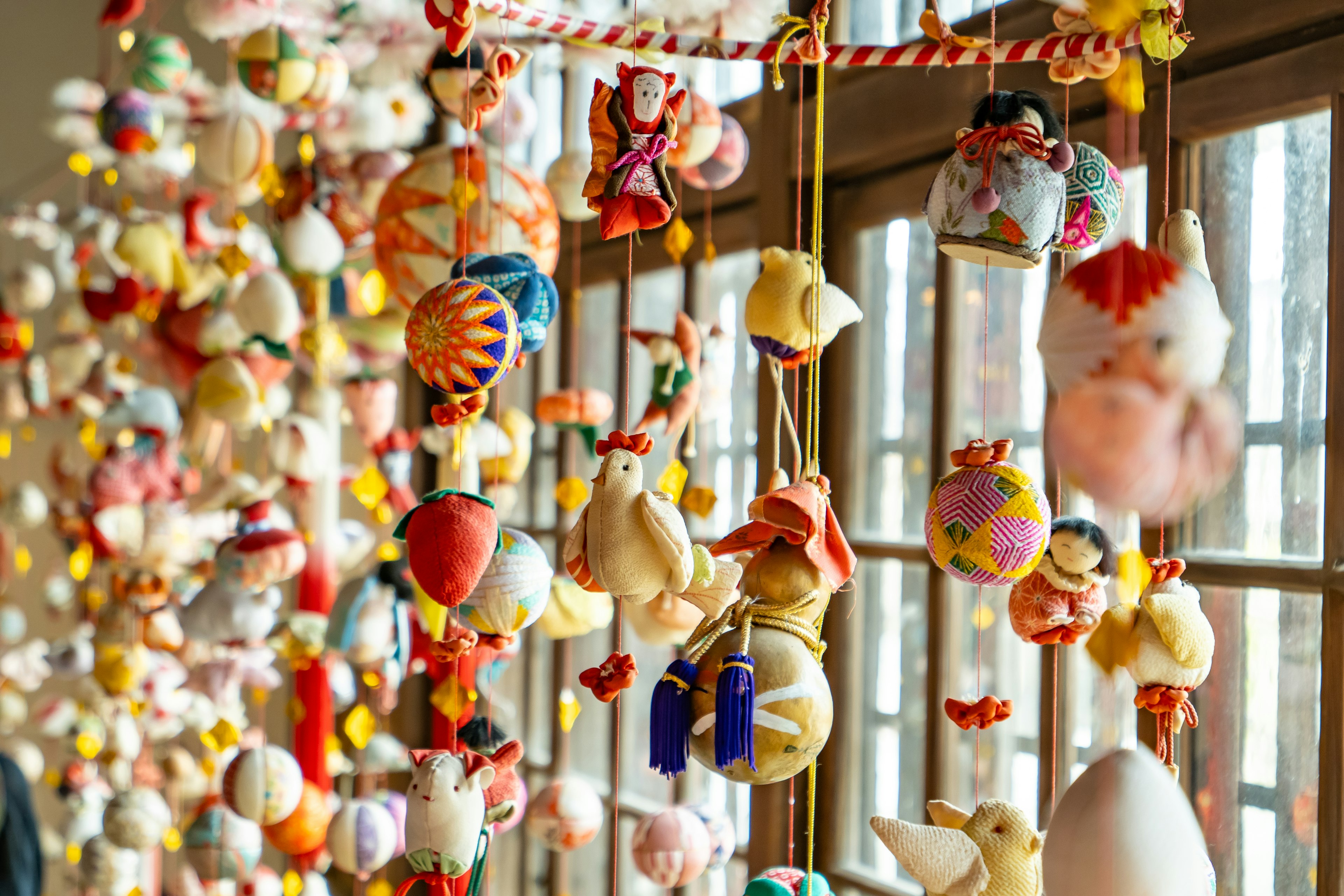 Ornements traditionnels colorés suspendus près d'une fenêtre