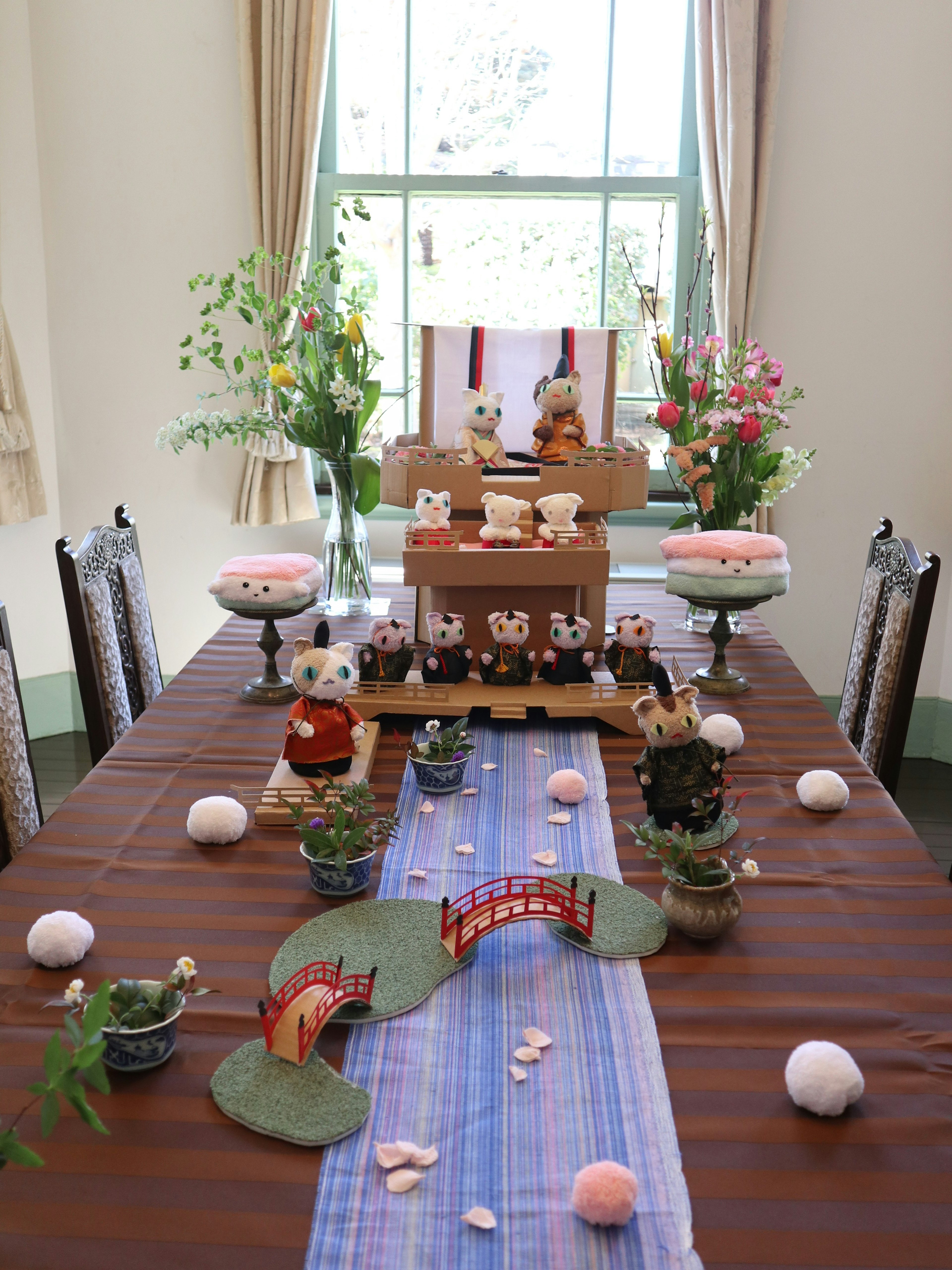 Dekorative Ausstellung für das Hina Matsuri-Festival auf einem Tisch mit Blumen