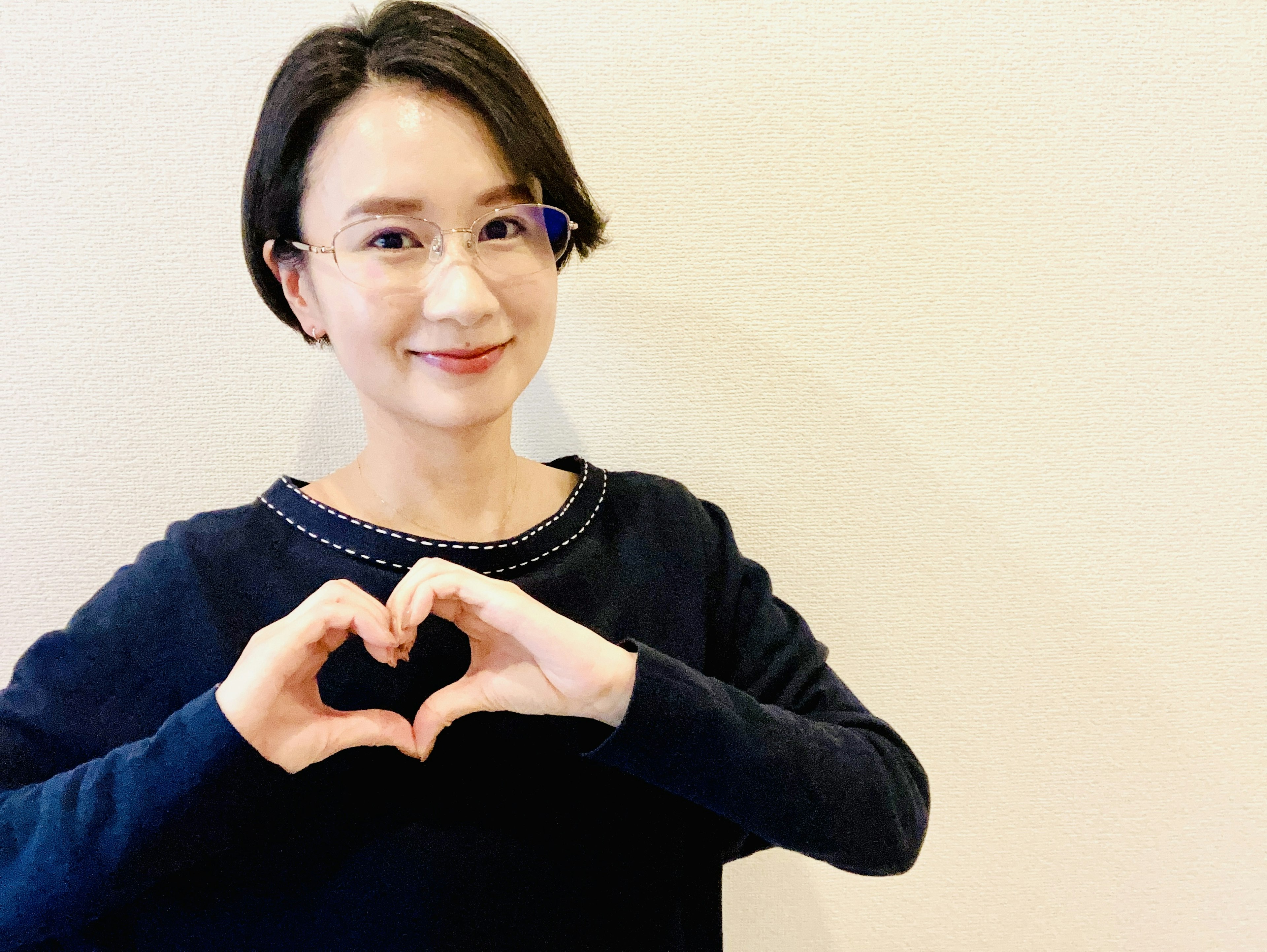 Mujer sonriendo y formando un corazón con las manos