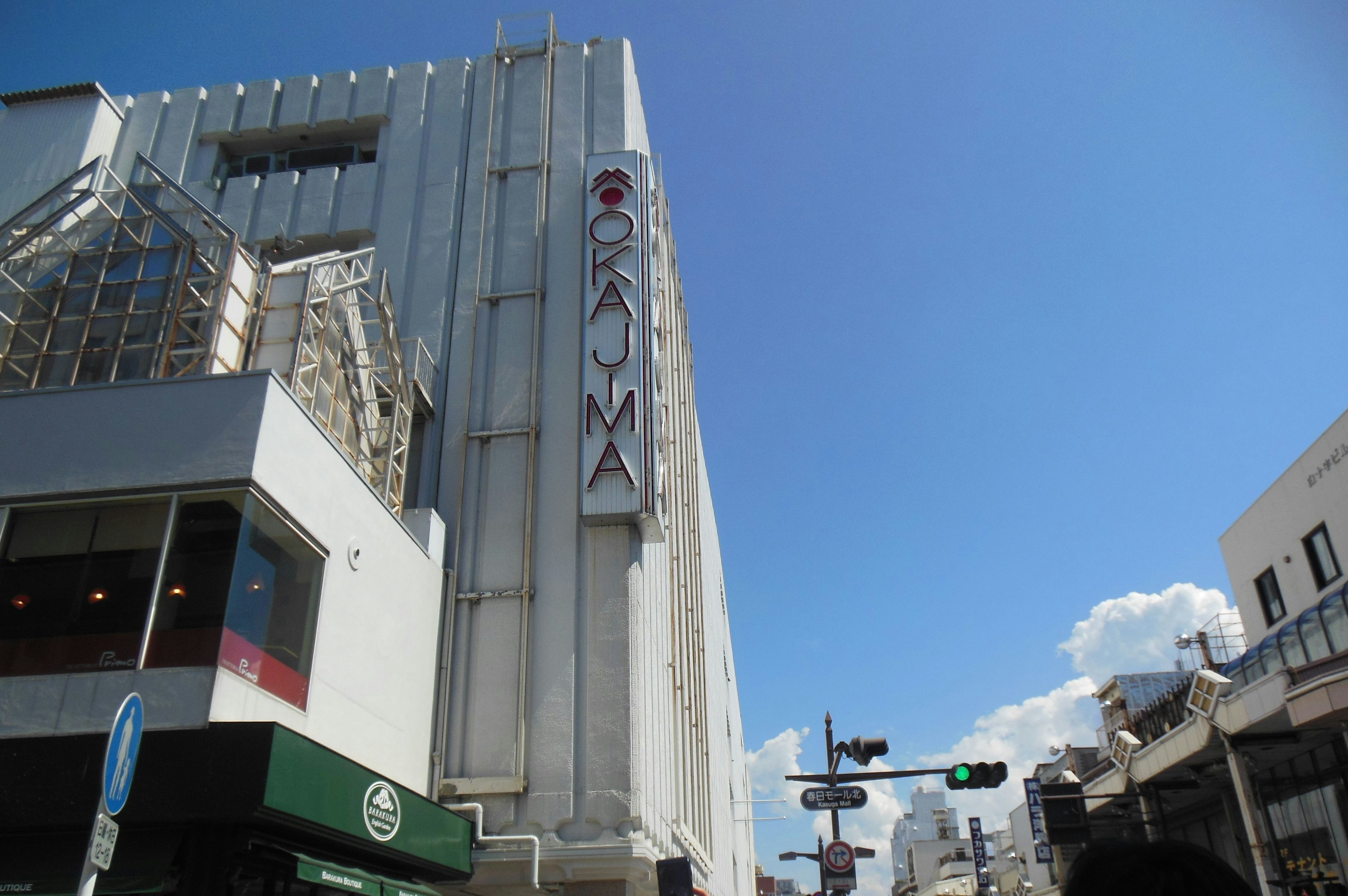 Cityscape featuring a white building and a prominent sign under a blue sky