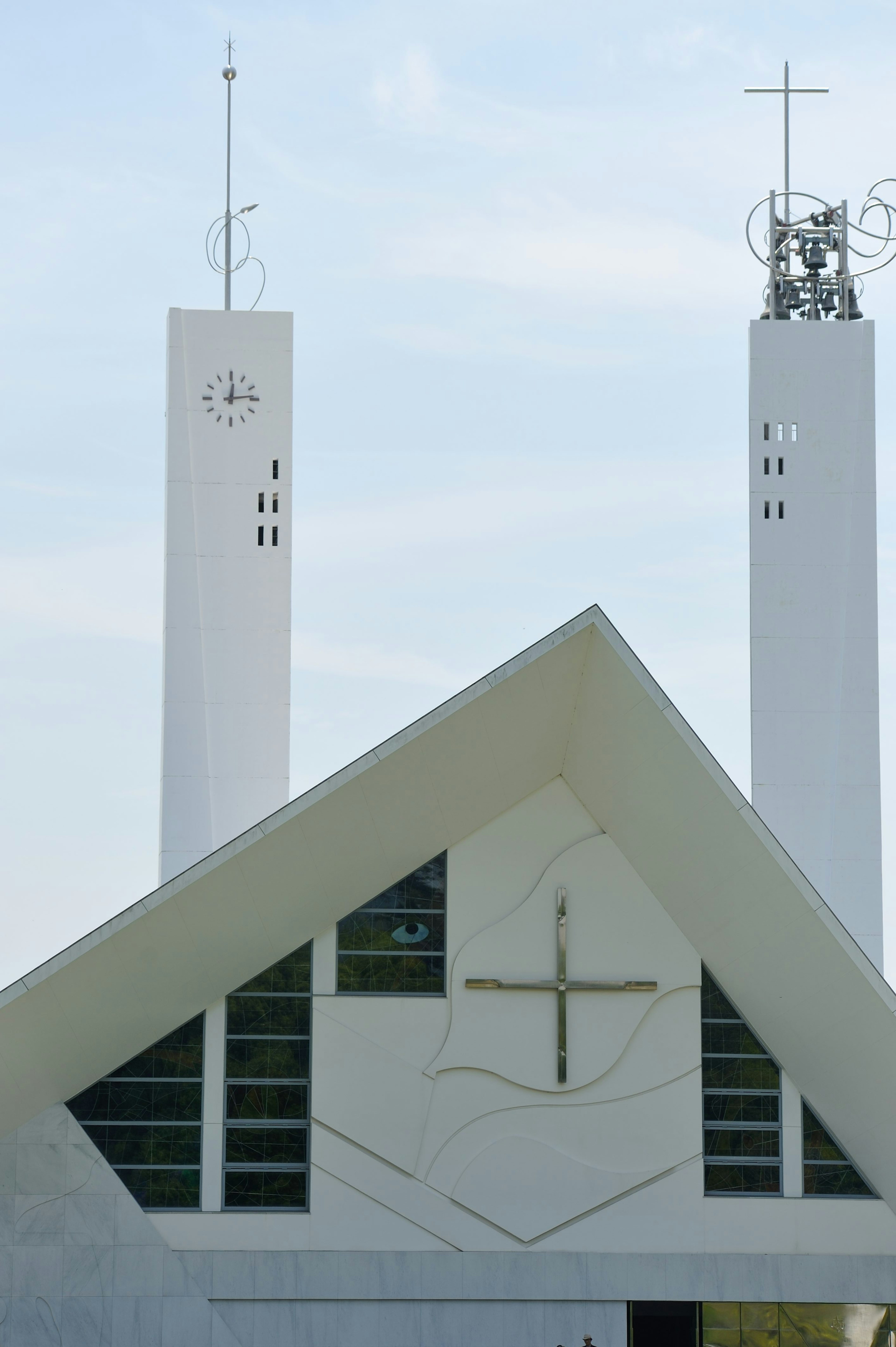 Edificio de iglesia blanca con torres distintivas y una cruz