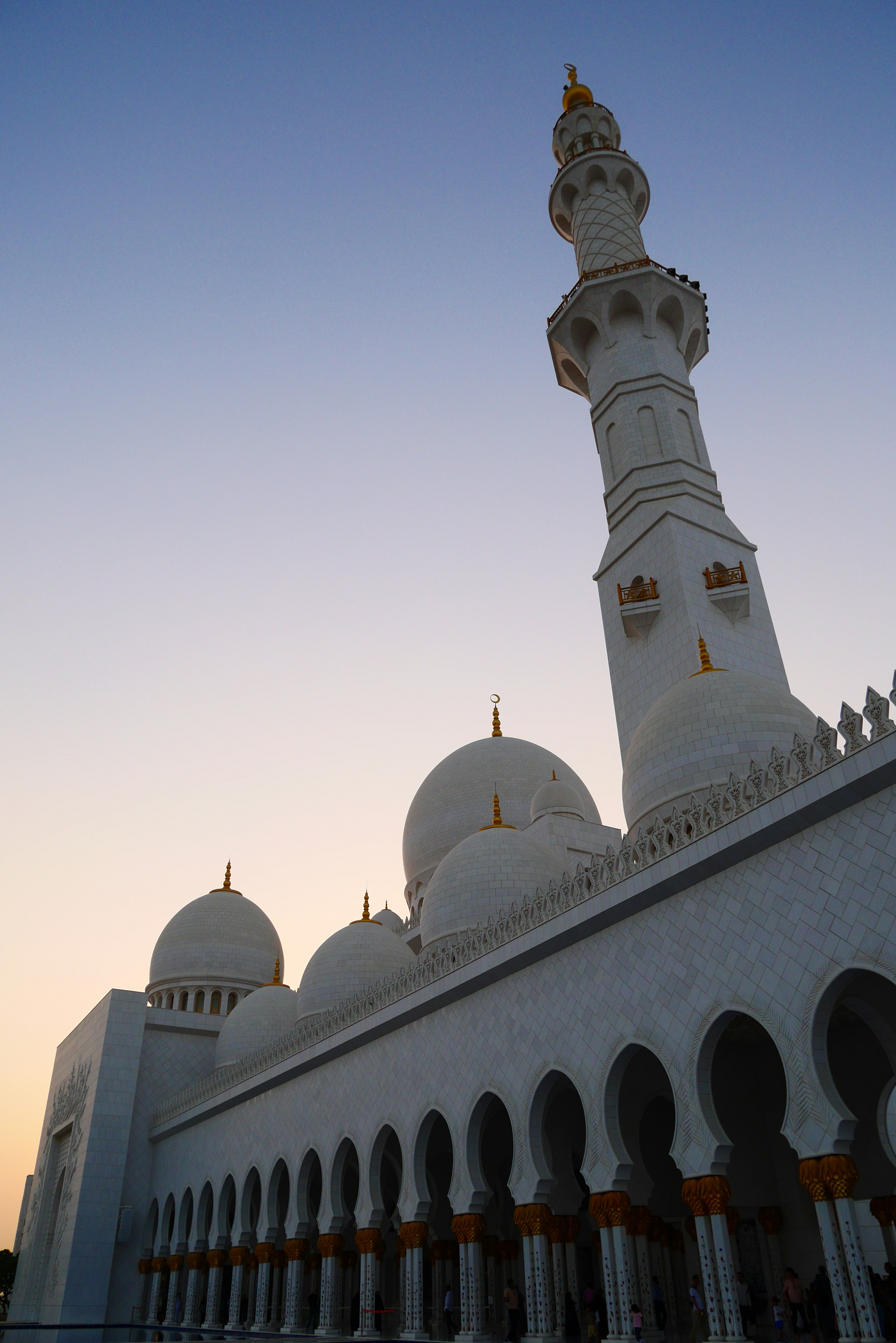 Beautiful view of a white mosque with a tall minaret against a sunset sky