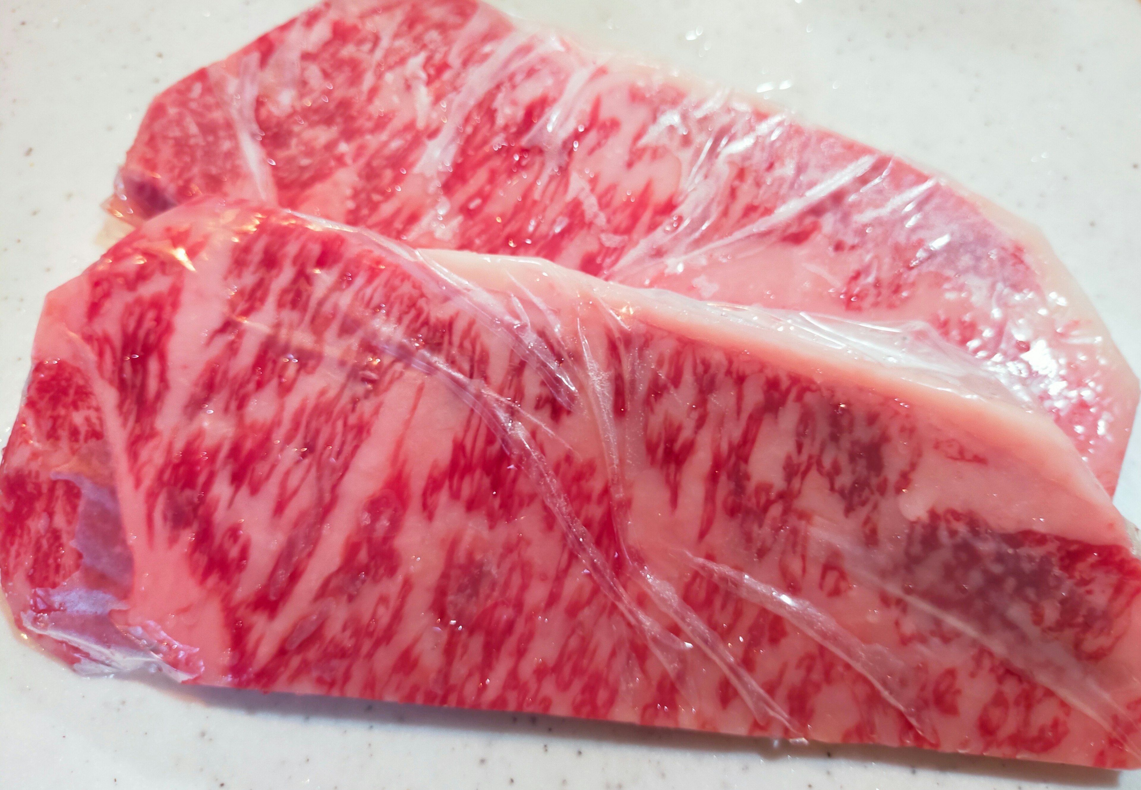 Beautiful marbled Wagyu beef wrapped in clear plastic