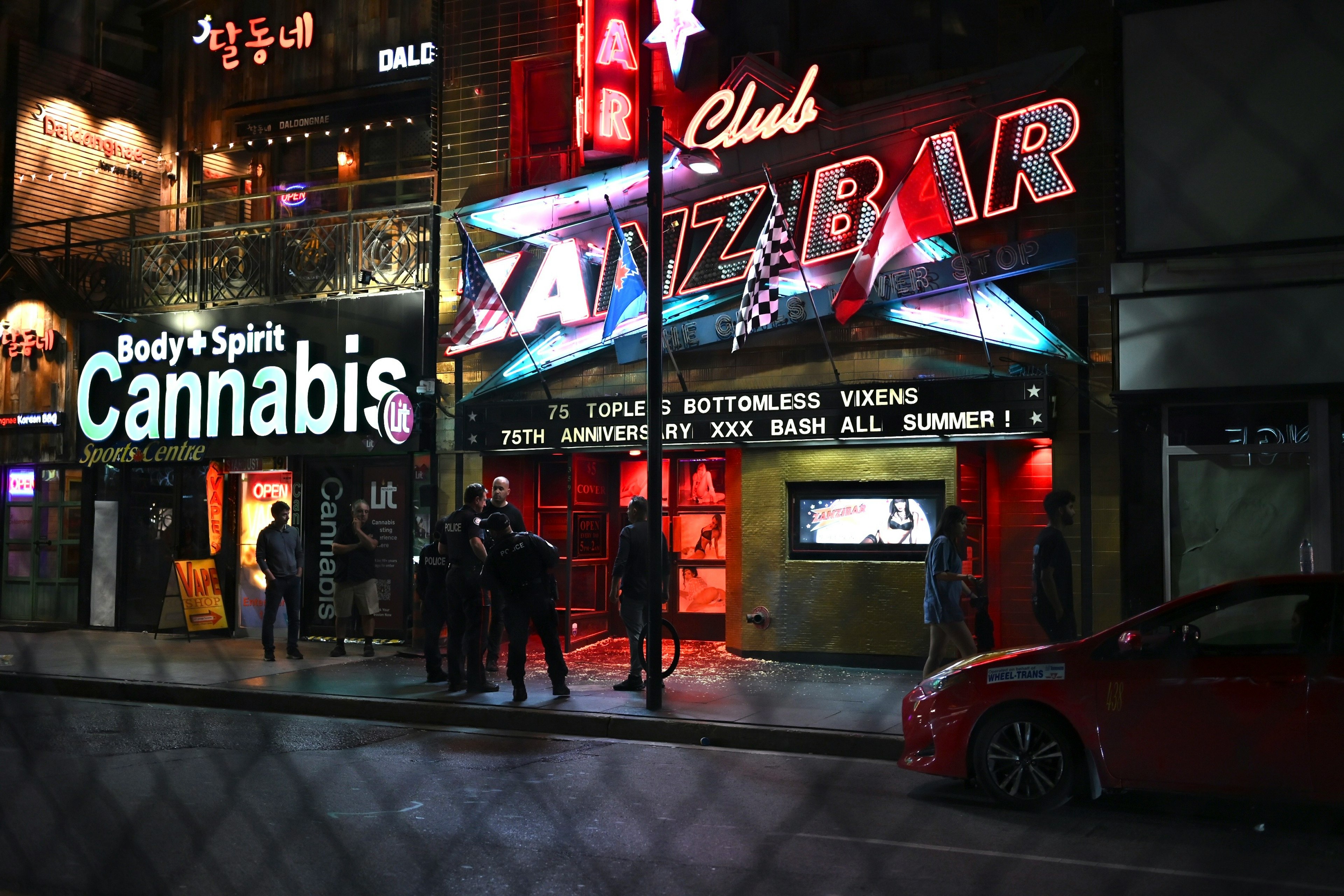 Colorful neon signs of Jazz Bar with people gathered outside