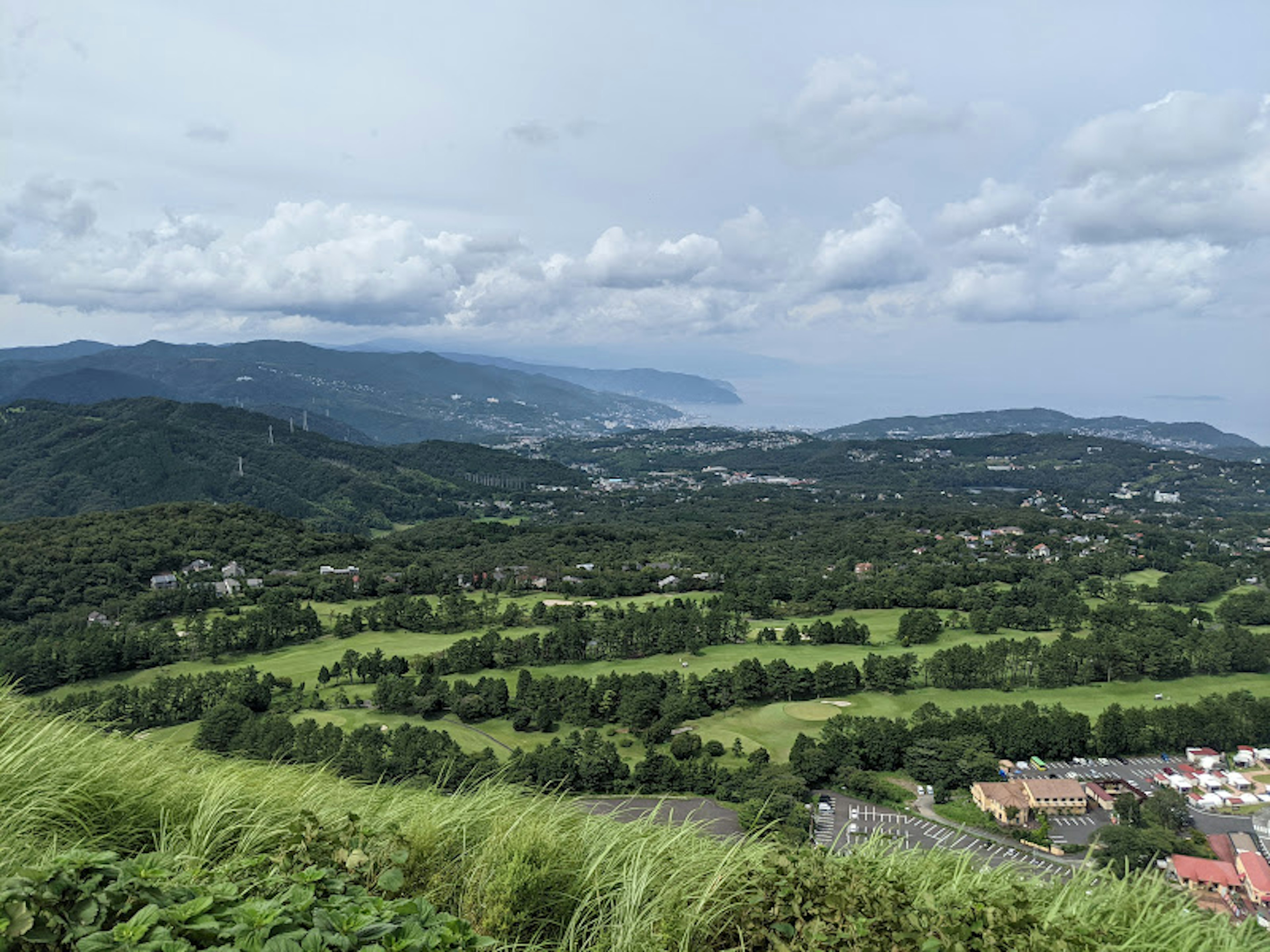 Vista escénica de colinas verdes y costa bajo un cielo nublado