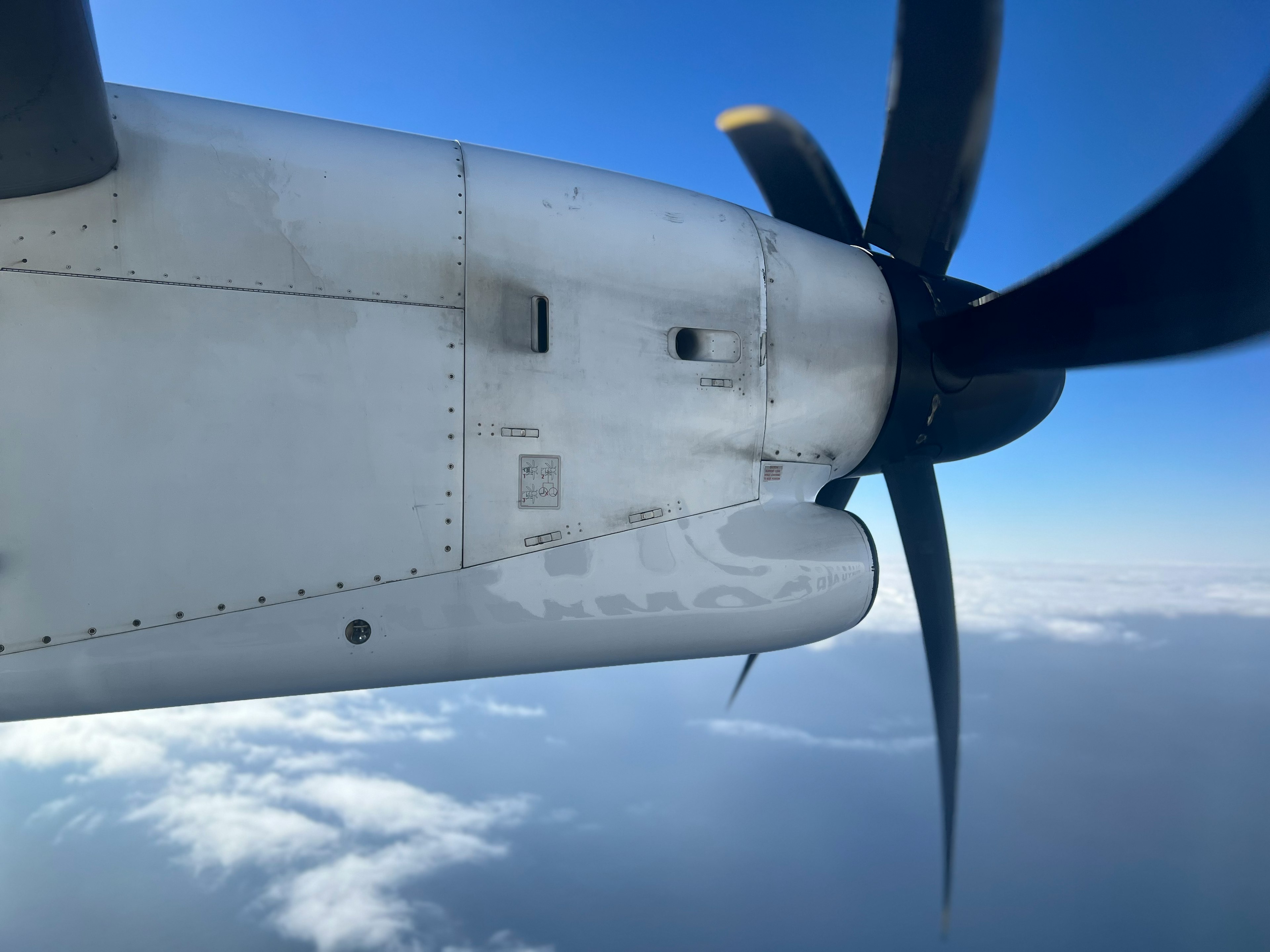 View of an airplane propeller and wing against the sky