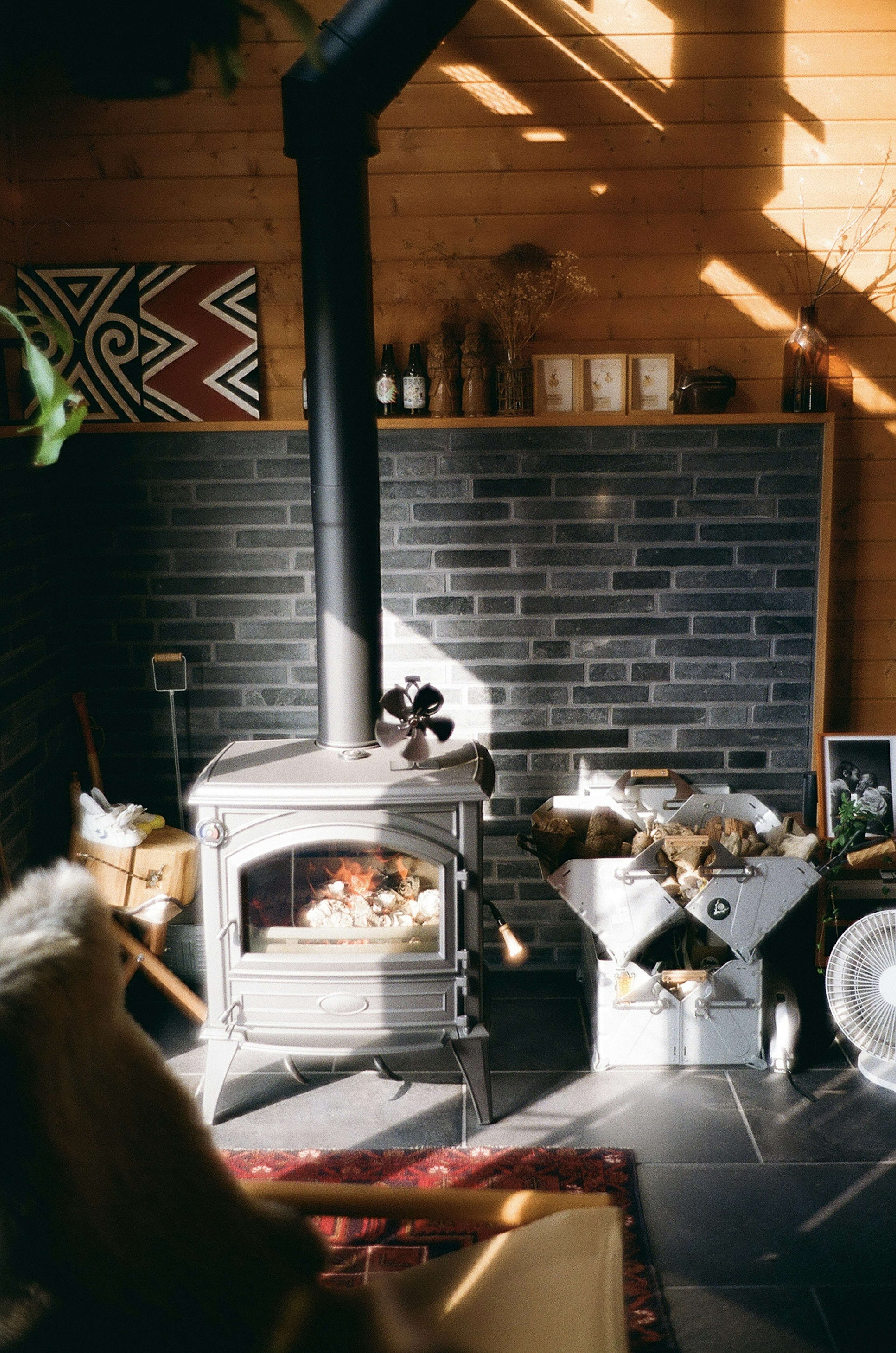 Scène intérieure confortable avec un poêle à bois et des murs en bois avec de la lumière du soleil qui entre