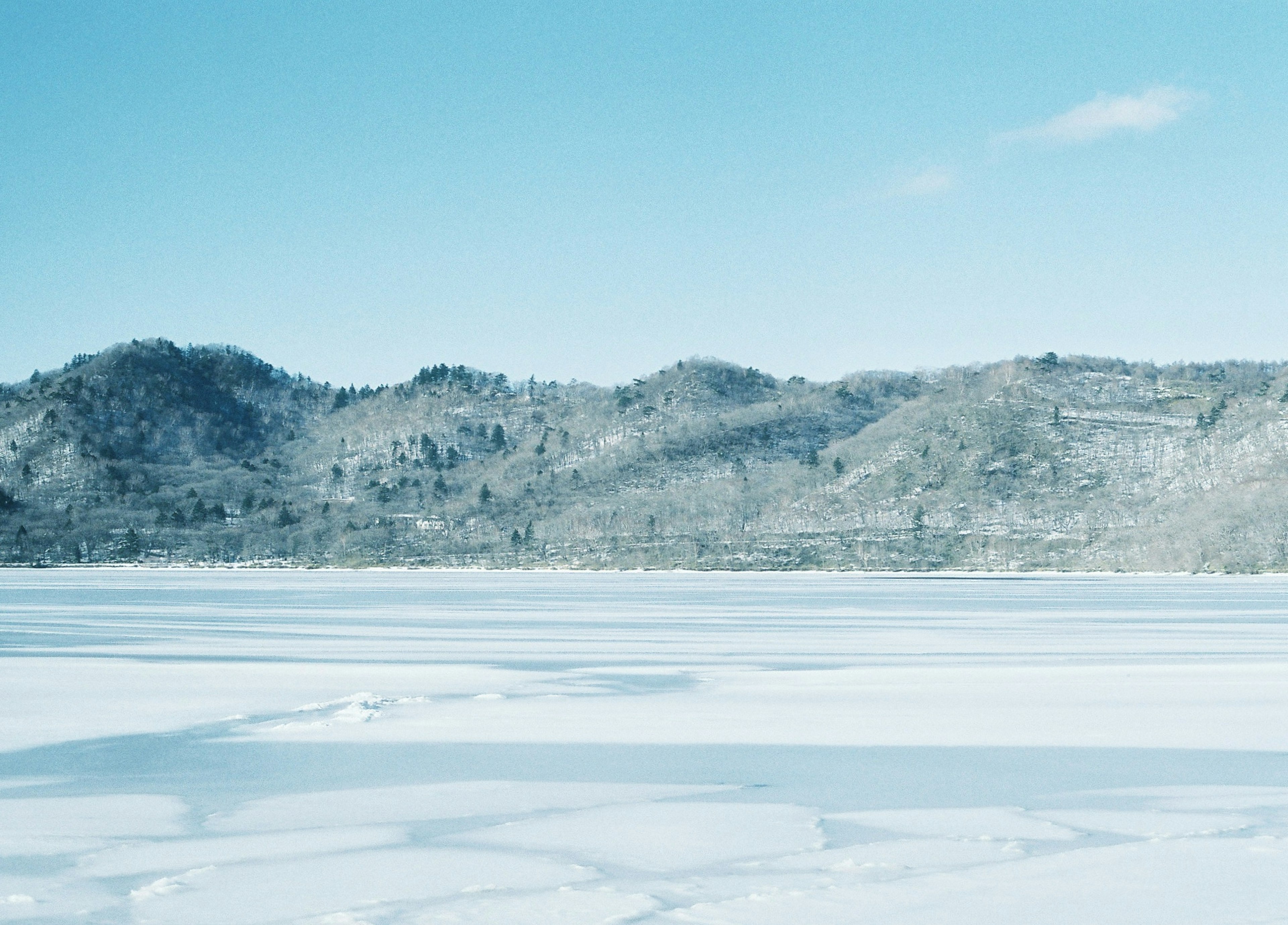 Schneebedeckte Landschaft mit Bergen und blauem Himmel