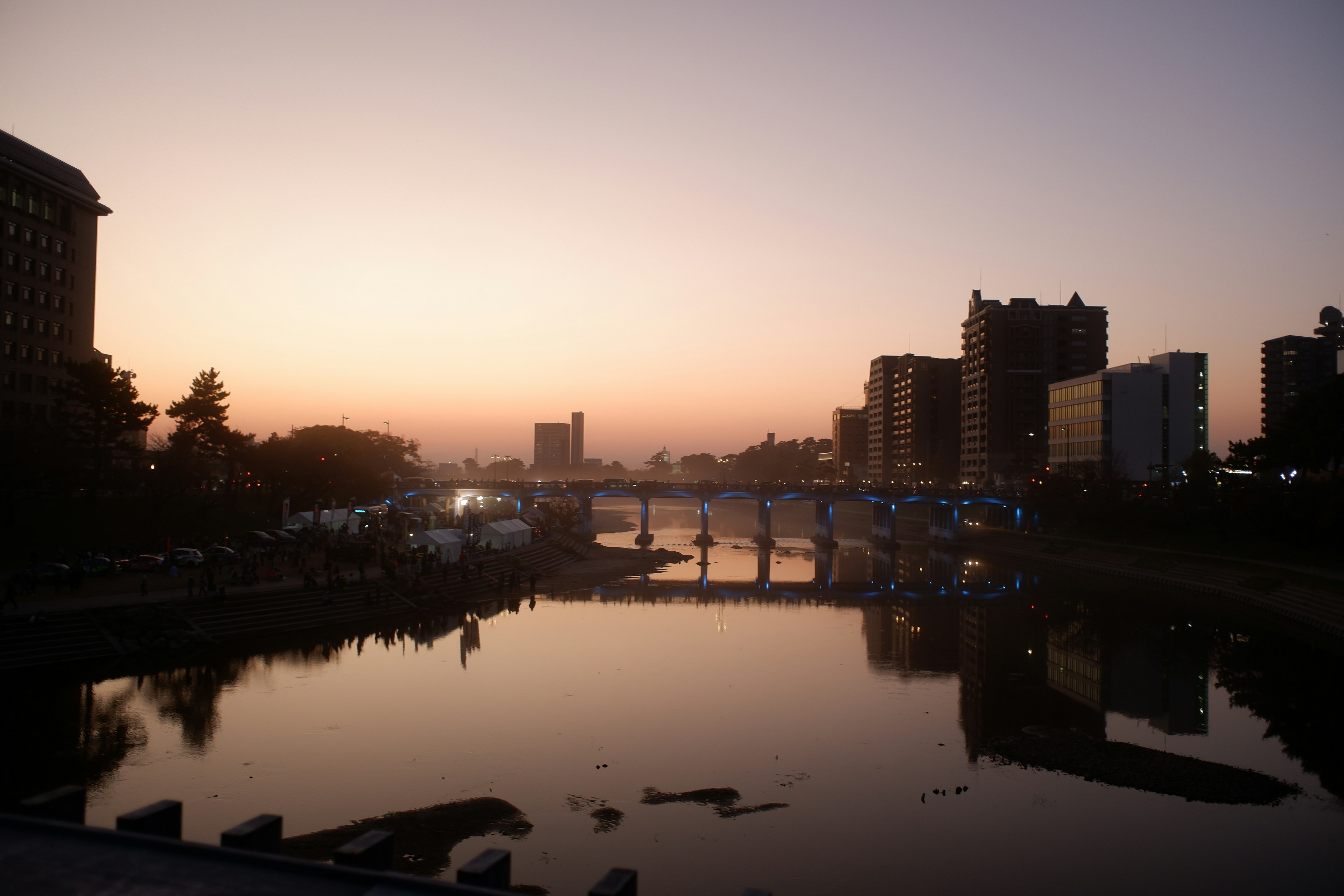 Paysage urbain au coucher du soleil avec une rivière réfléchissant les bâtiments