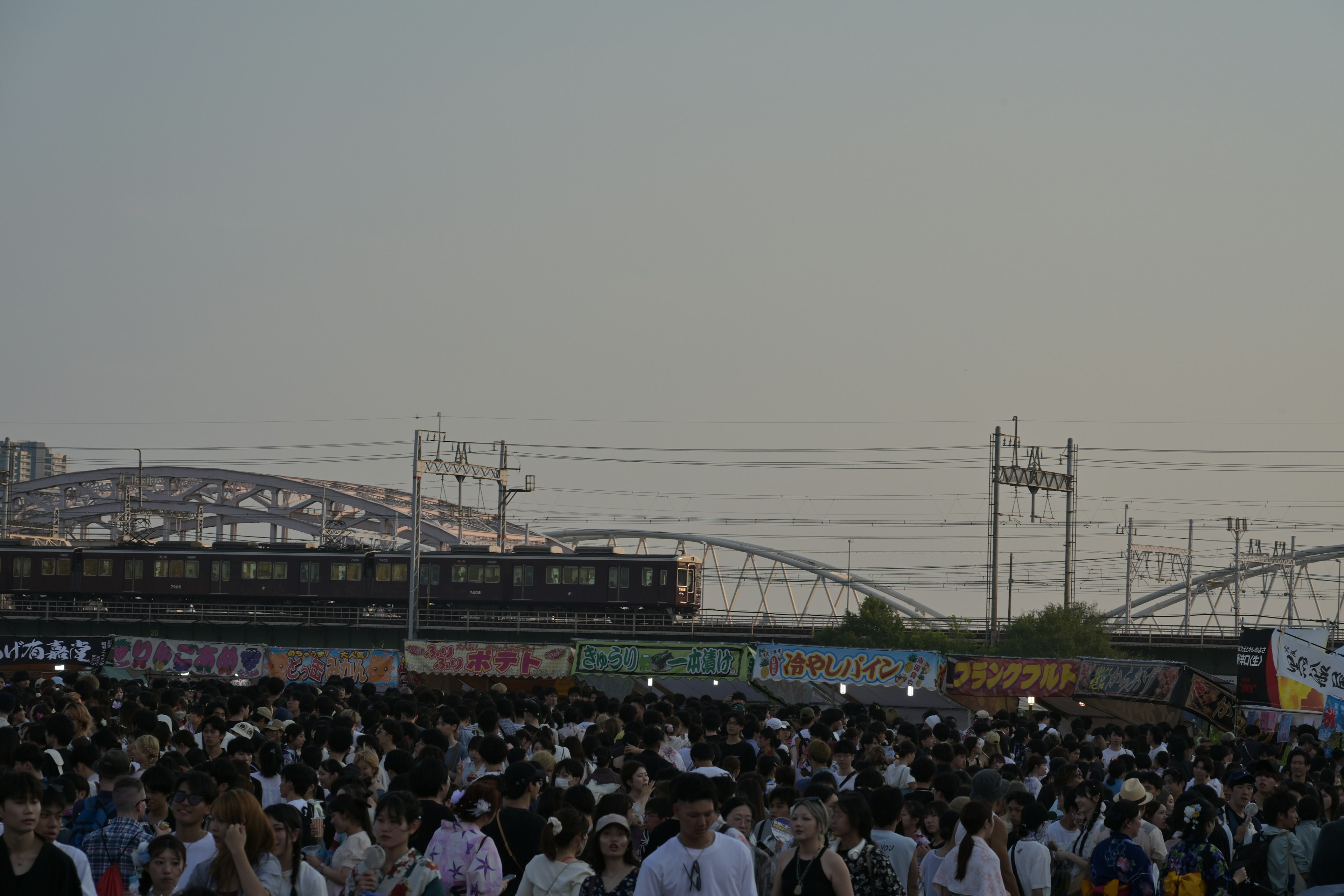 Multitud de personas en una estación con un tren que pasa