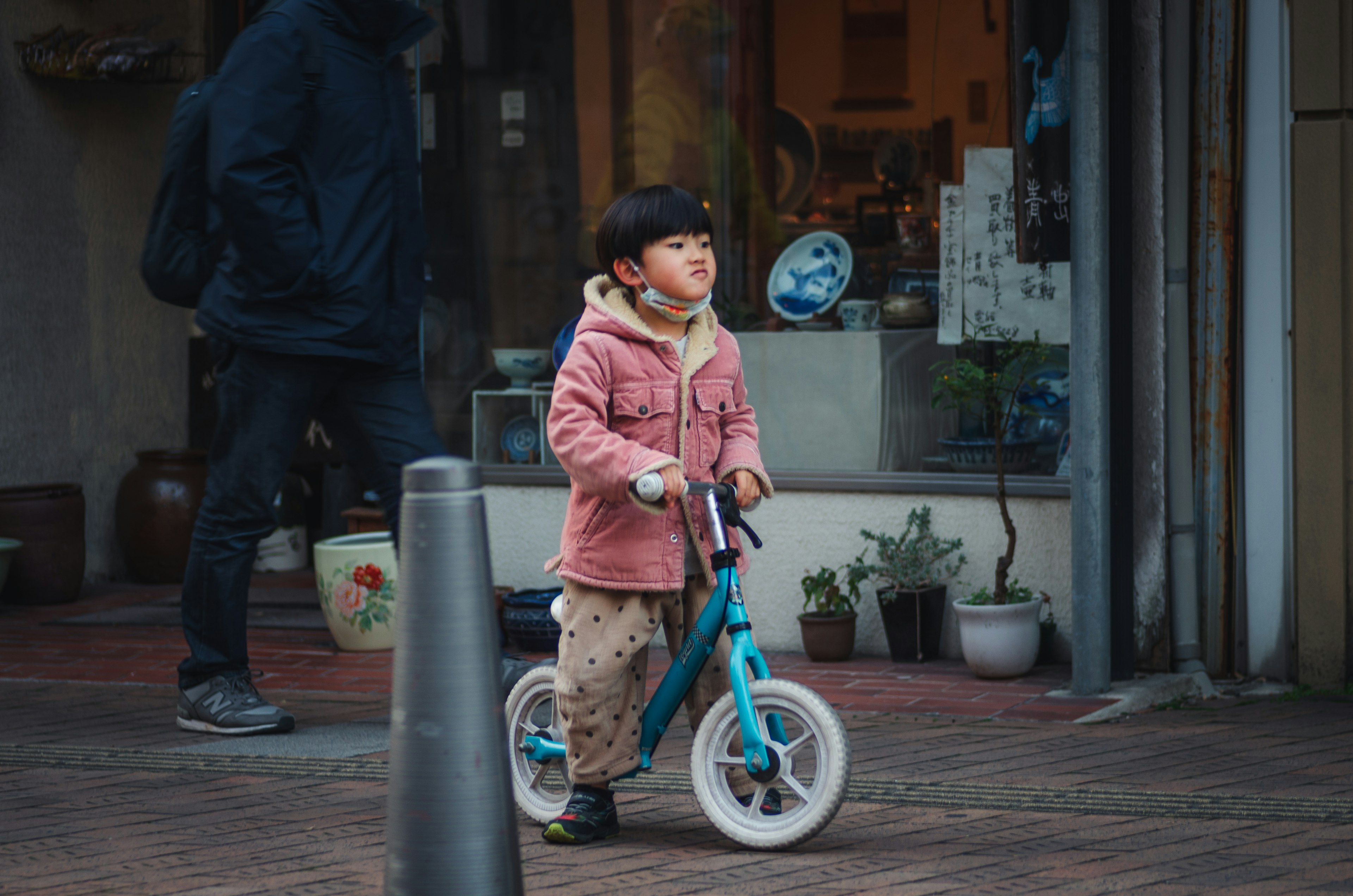 Child riding a blue bicycle on a city street