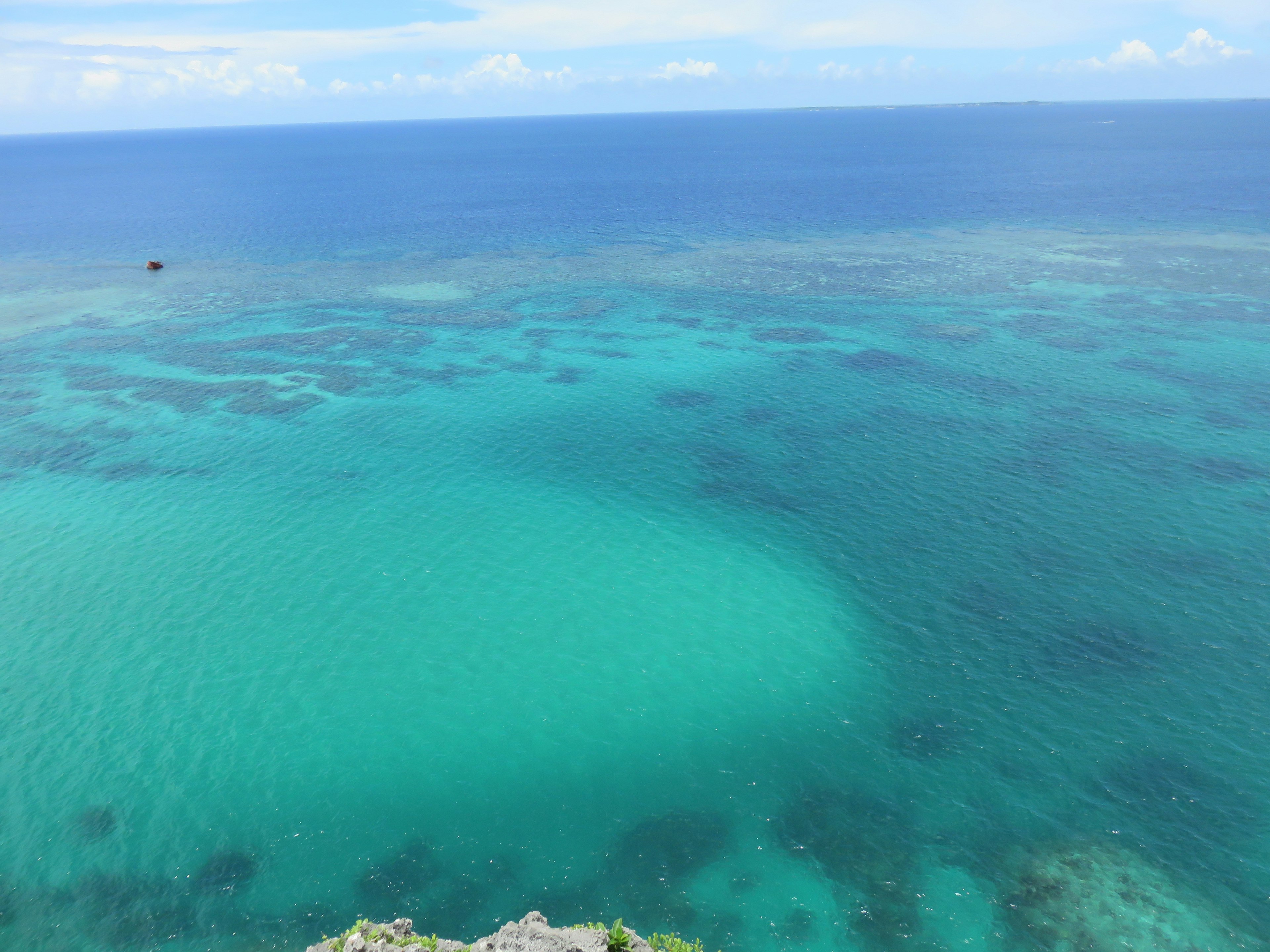 Laut turquoise yang cerah di bawah langit biru