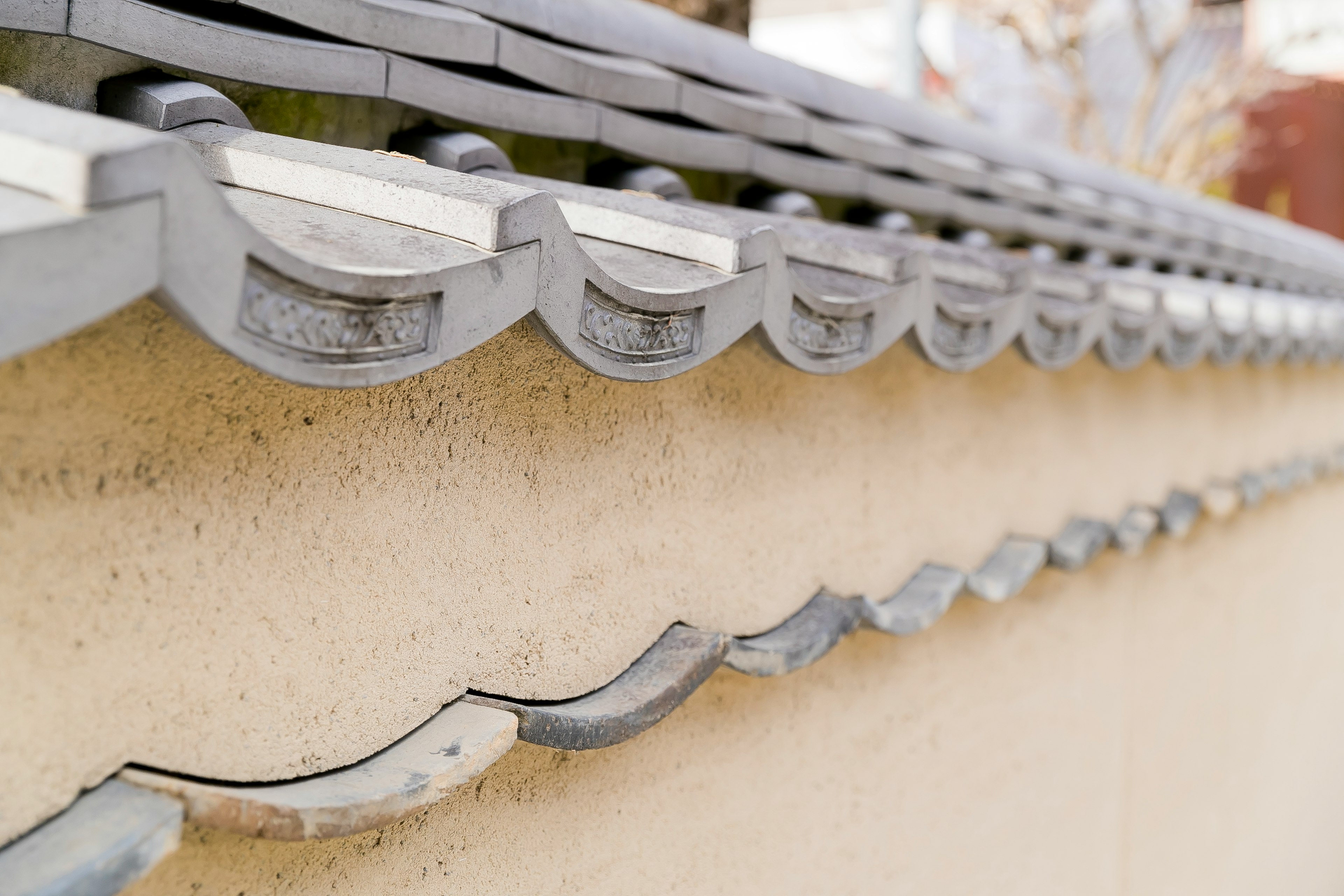 Traditional Japanese tile roof design with a section of earth wall