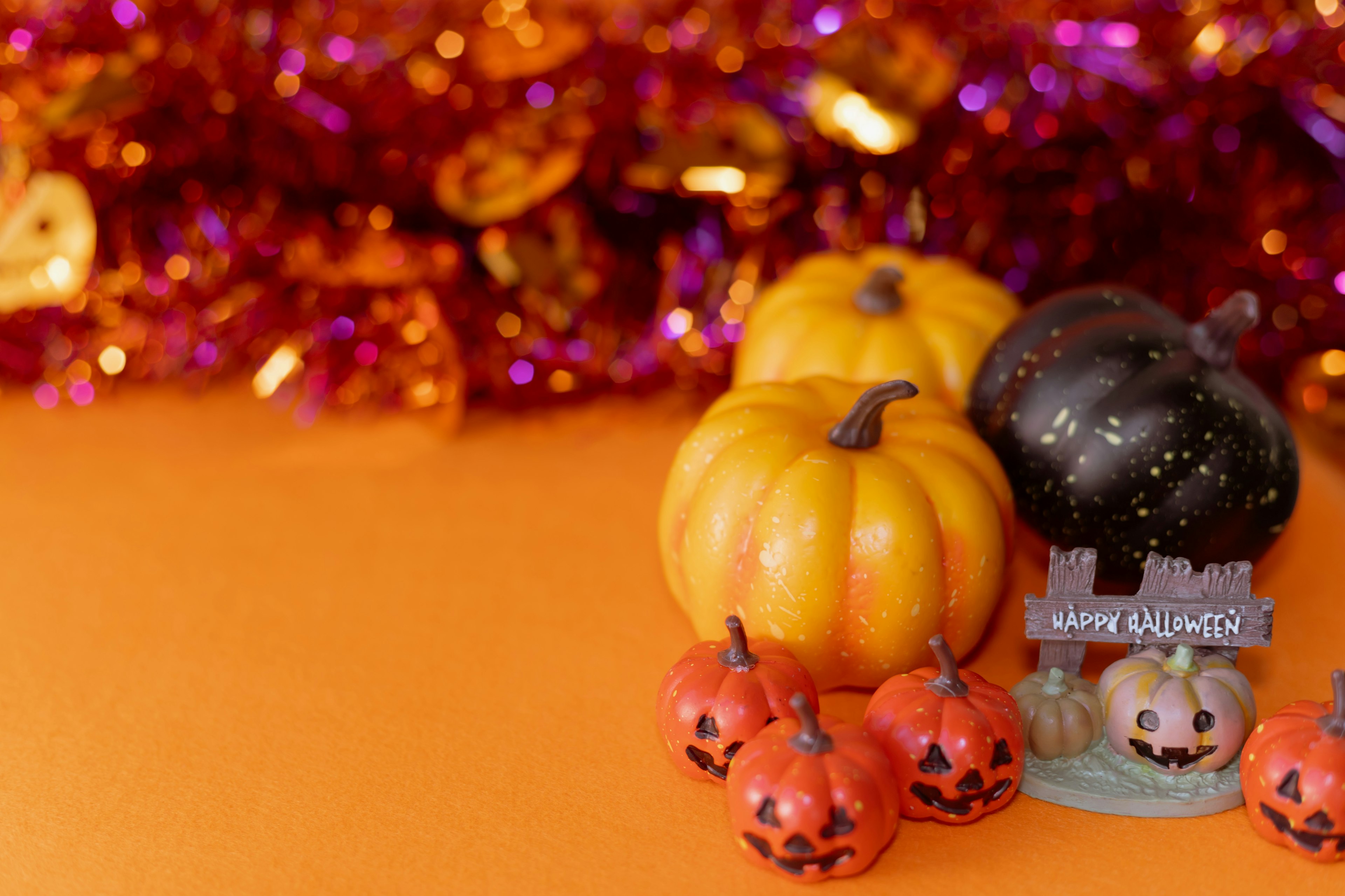 Decorazioni colorate di Halloween con piccole zucche su uno sfondo arancione