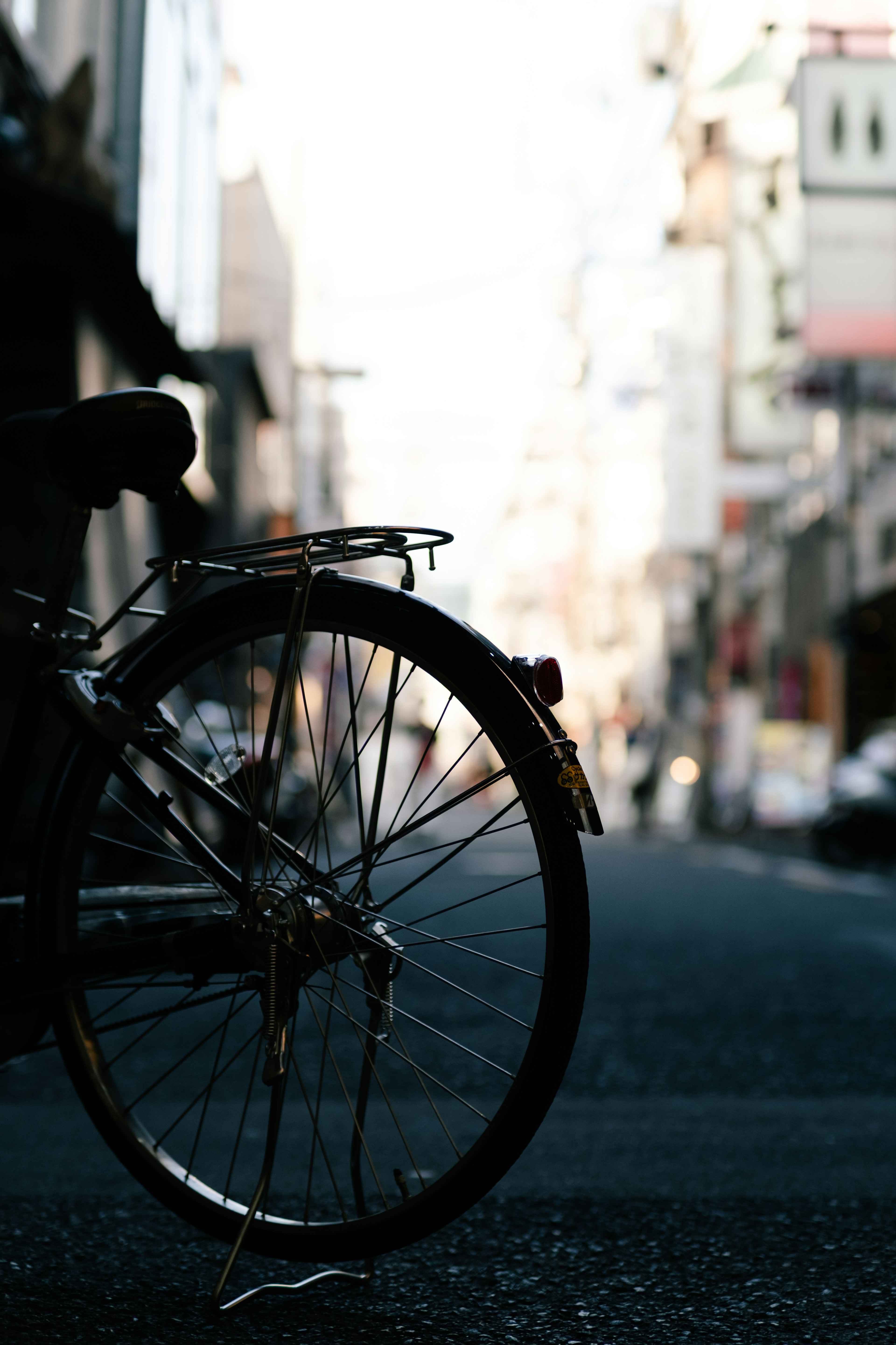 Close-up of a bicycle rear wheel with a city background