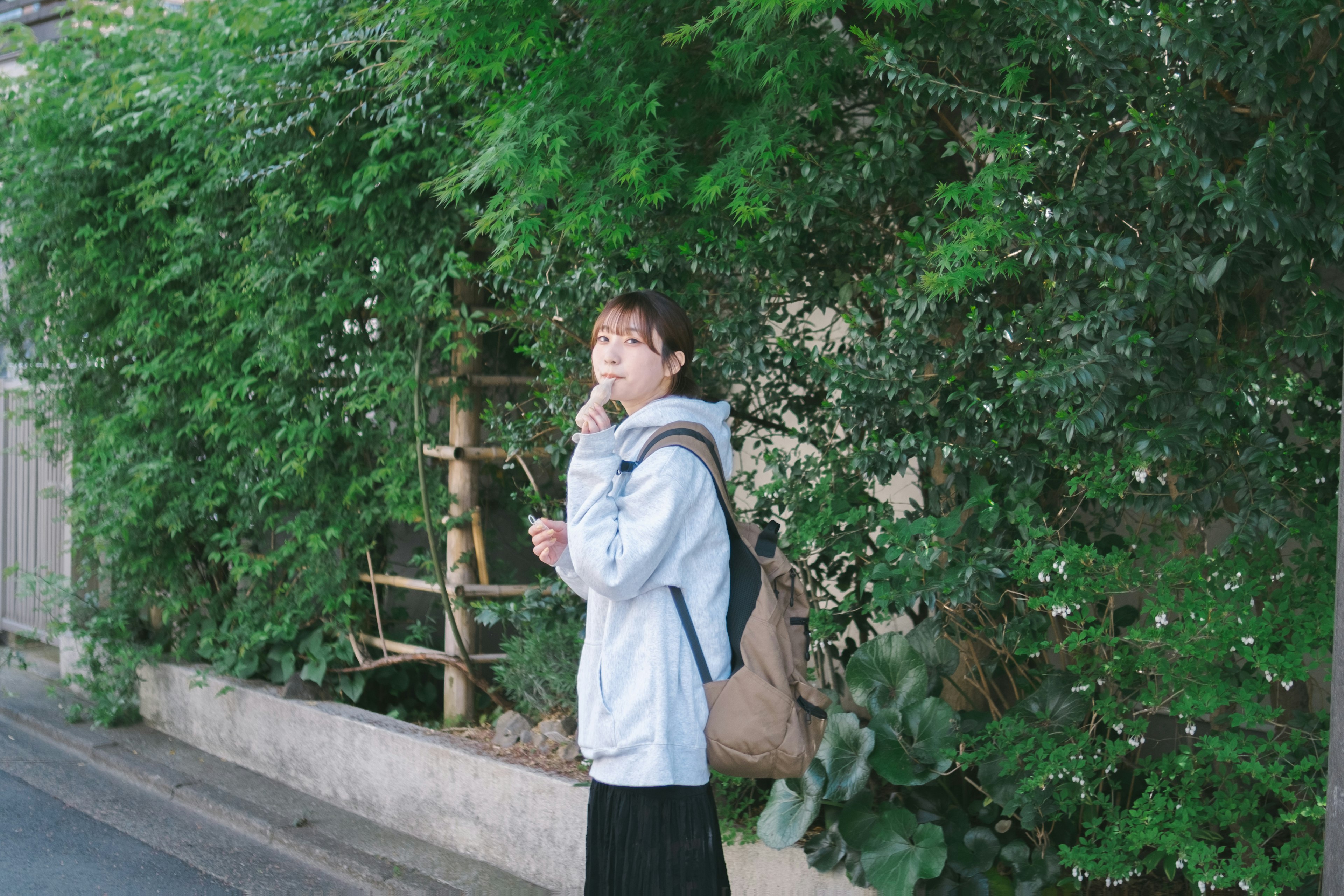 A woman smoking in front of a green backdrop