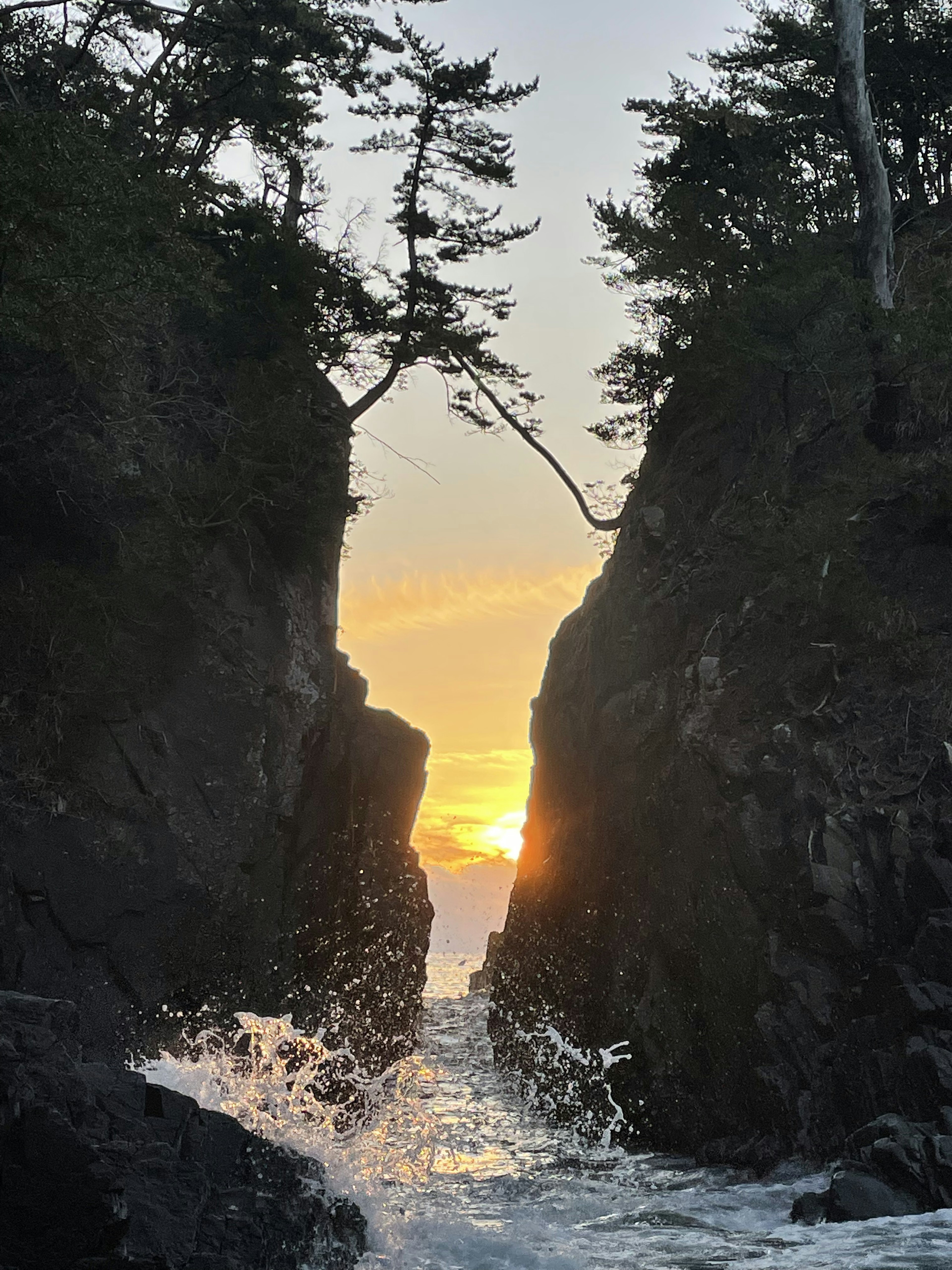 日落在岩石悬崖和海浪之间的风景