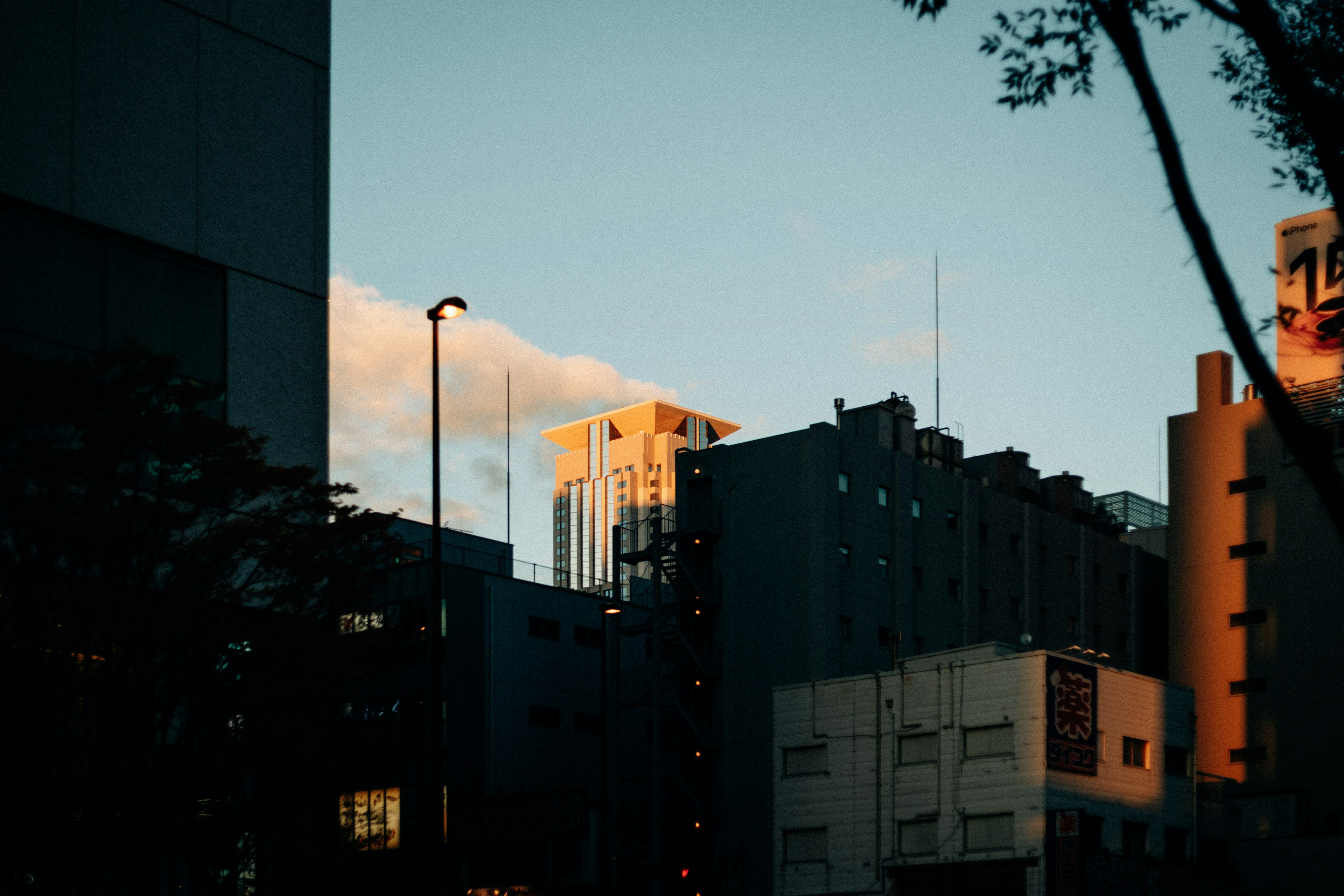 Paisaje urbano al atardecer con siluetas de edificios altos y luz naranja