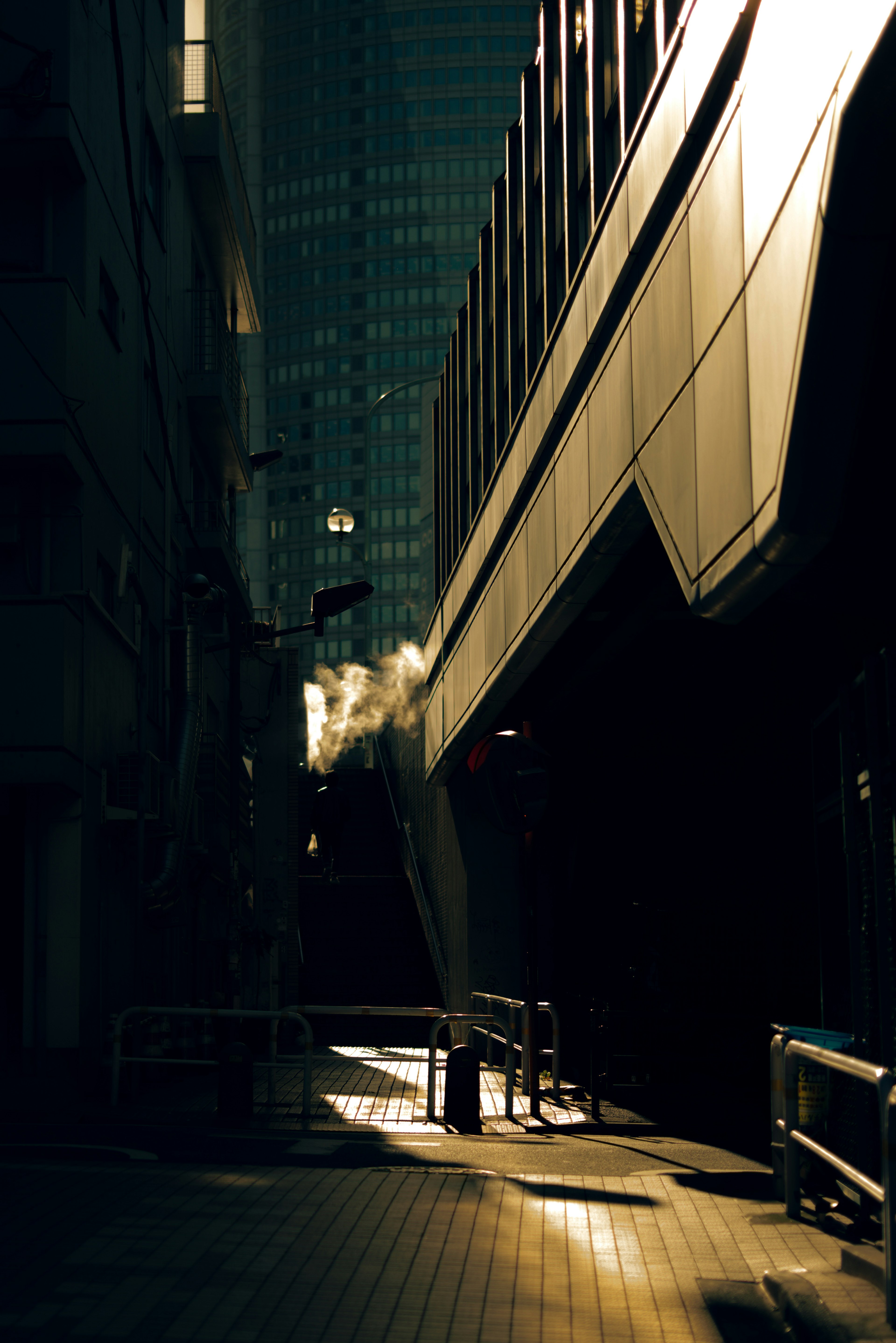 Luz que entra por un callejón estrecho con sombras de edificios