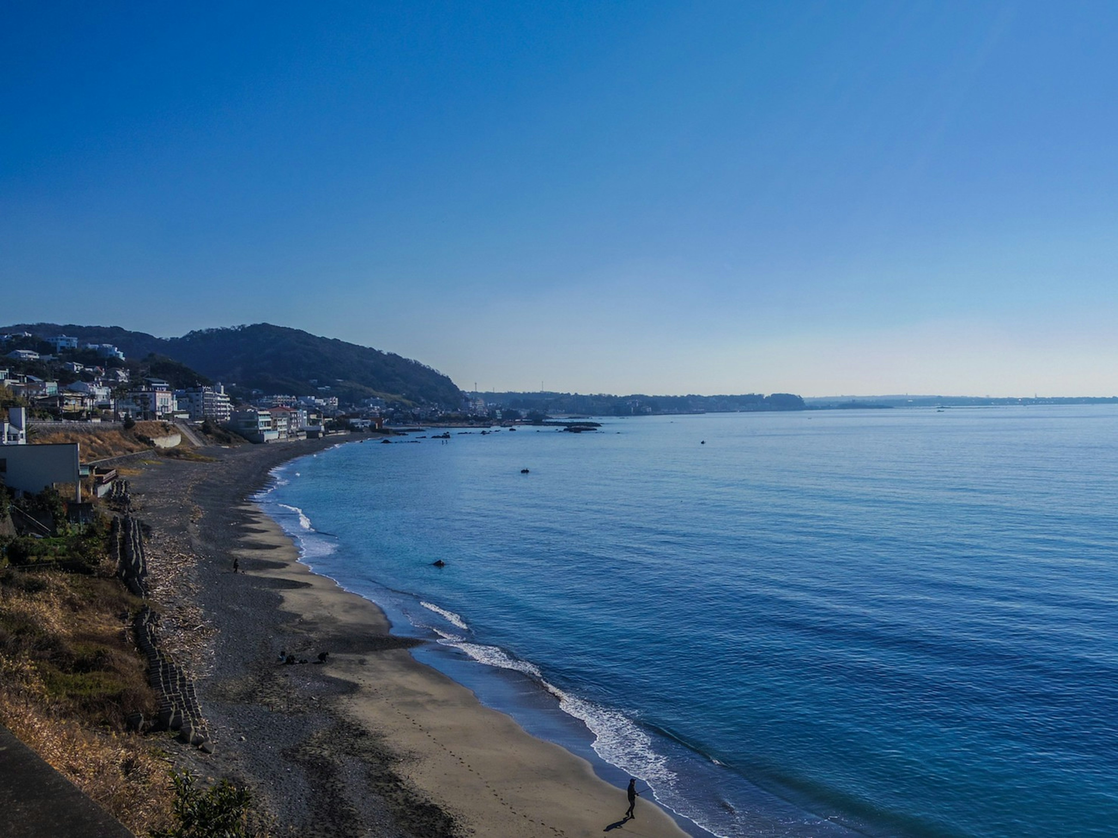 Scenic view of calm ocean and clear blue sky Beach and town in the distance