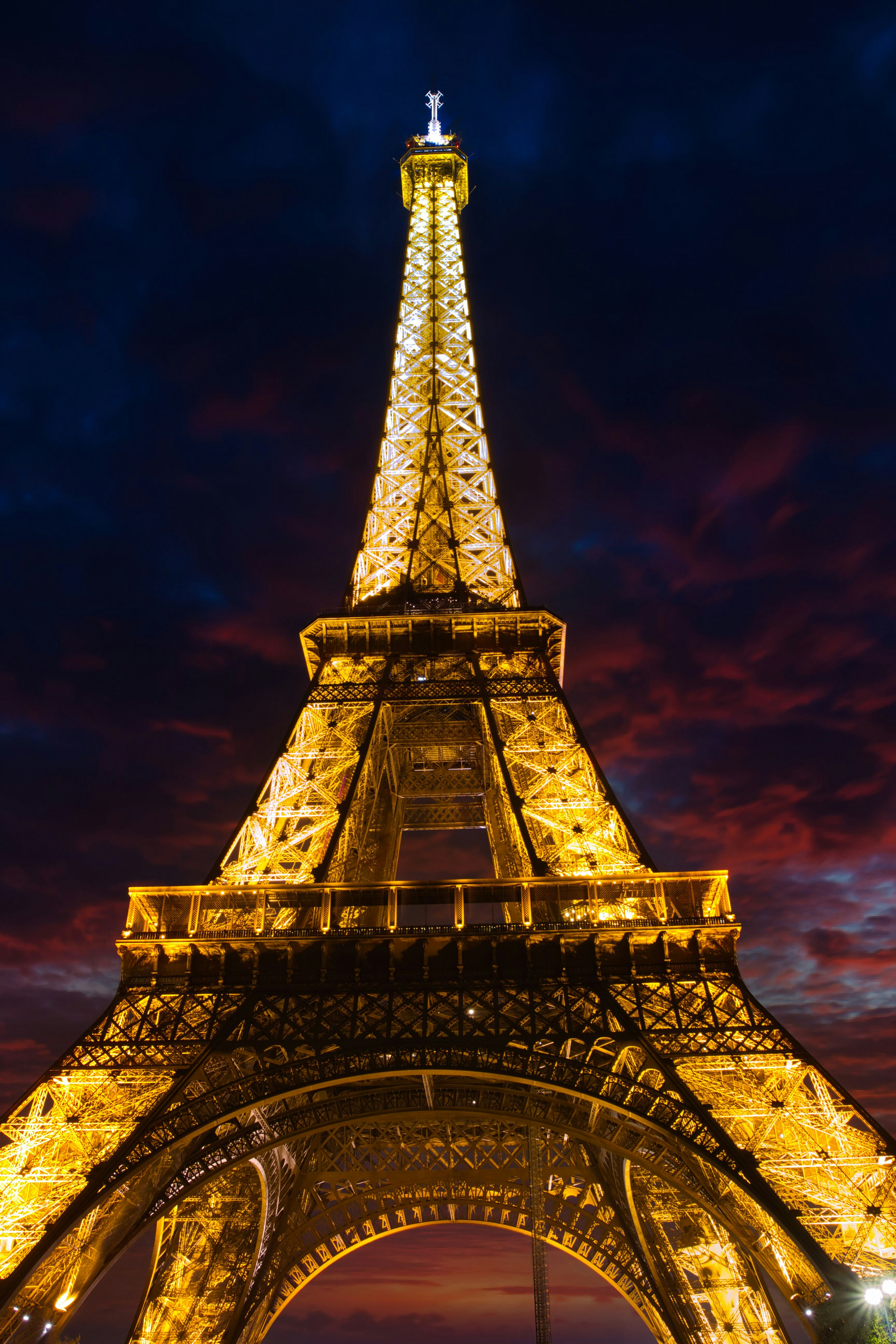 Torre Eiffel illuminata contro un cielo serale drammatico