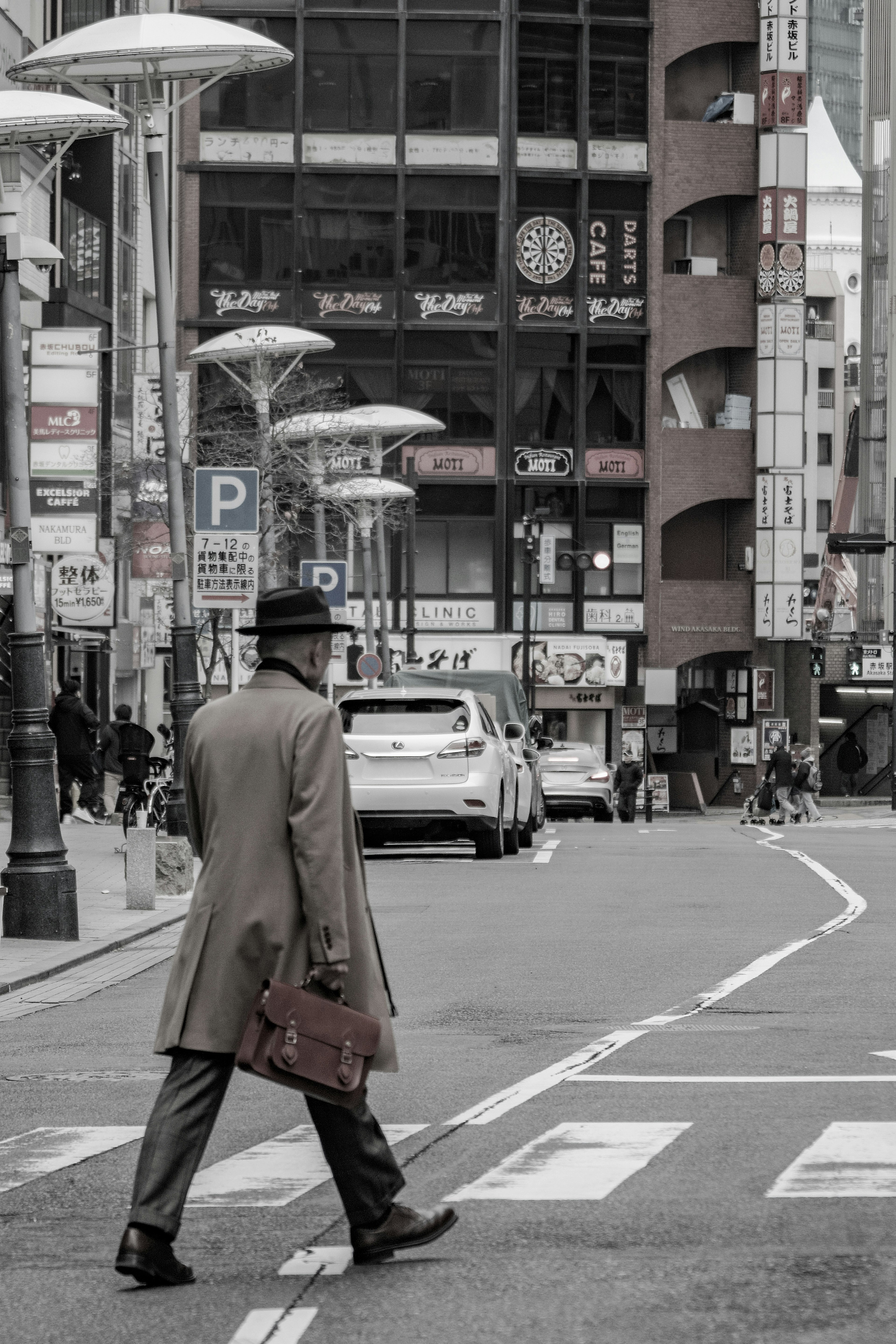 A man in a coat walking on the street in an urban setting