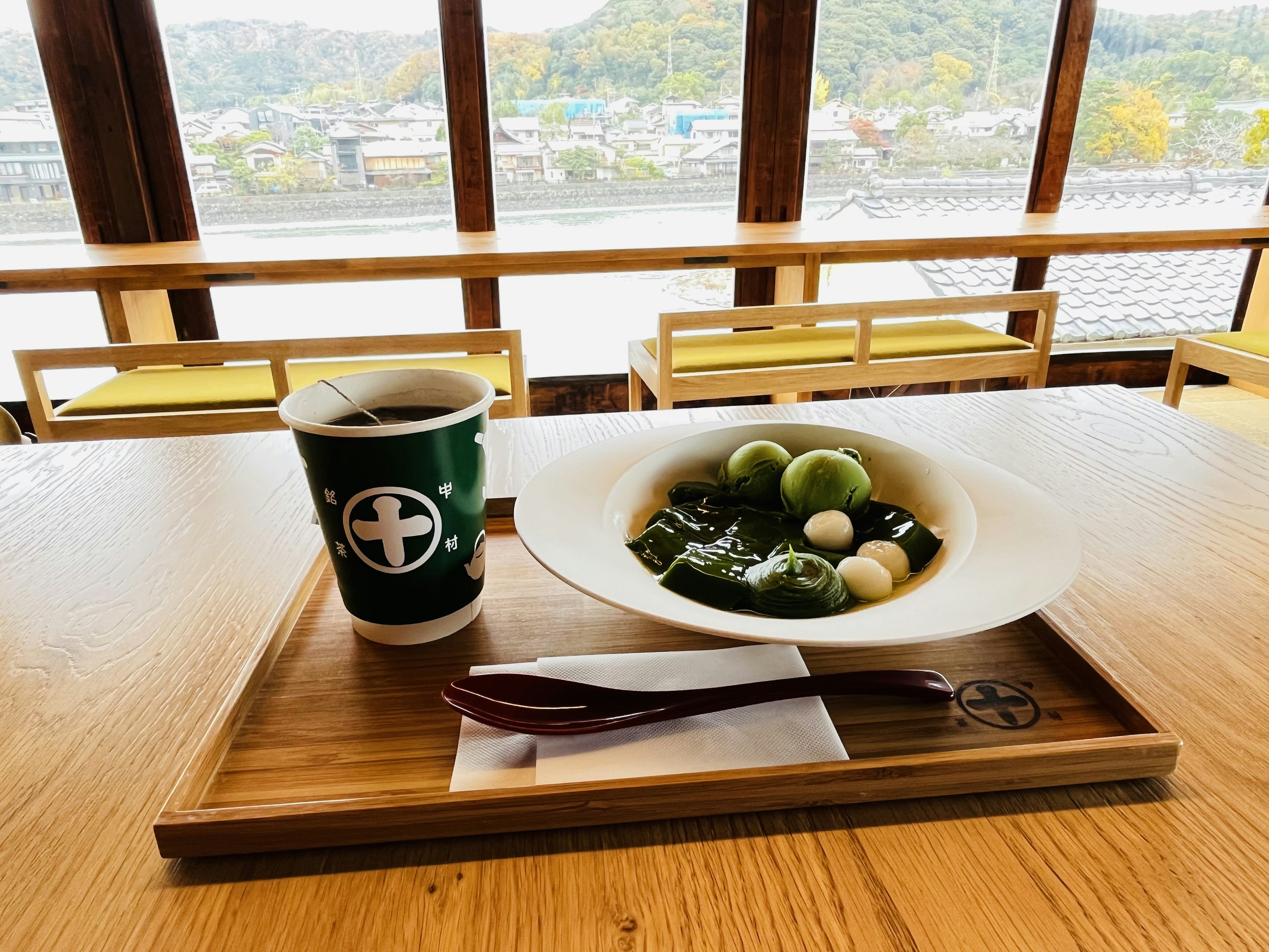 Conjunto de comida japonesa con bebida verde frente a un fondo escénico