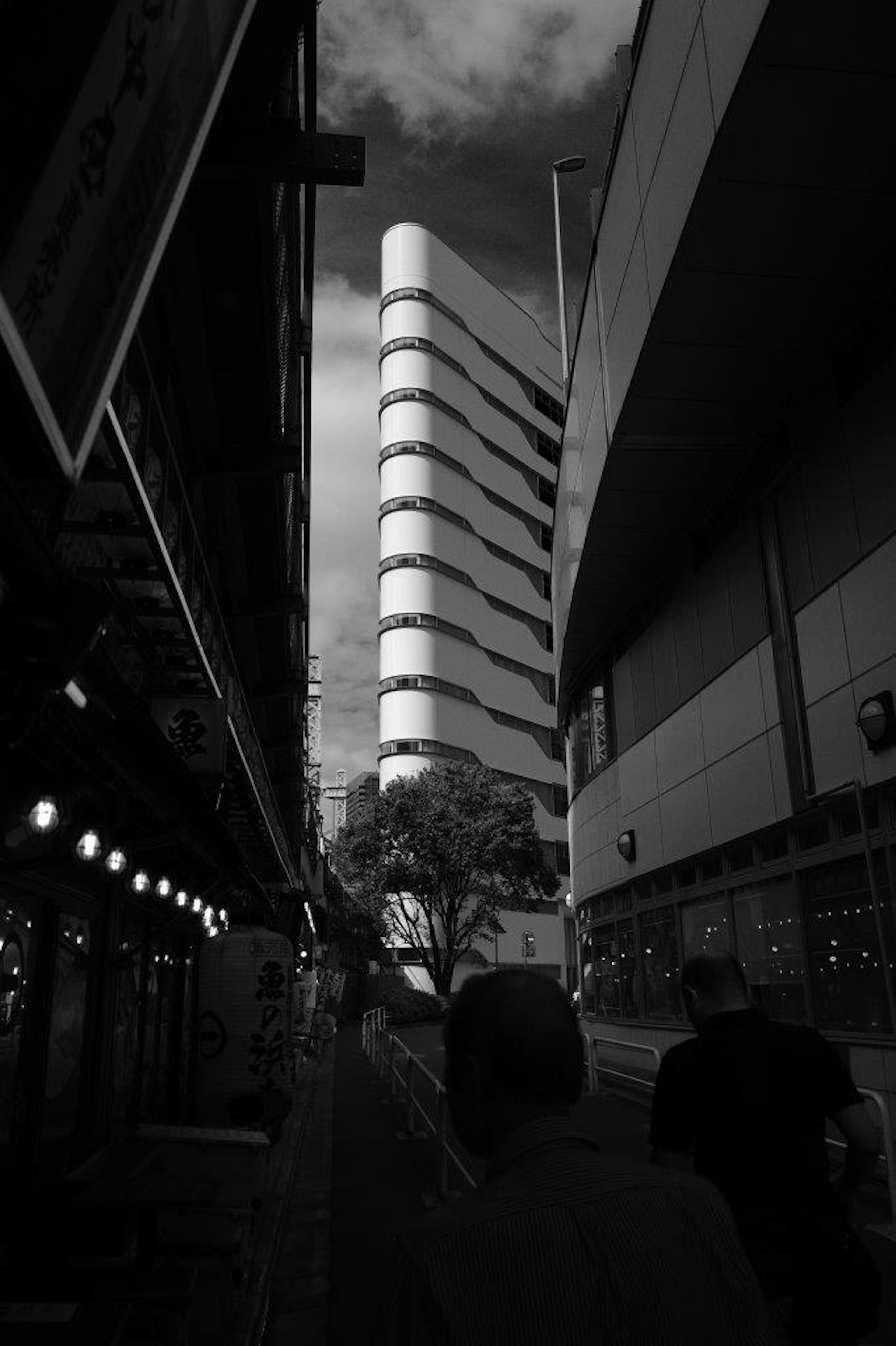 Escena urbana en blanco y negro con un edificio curvado destacado