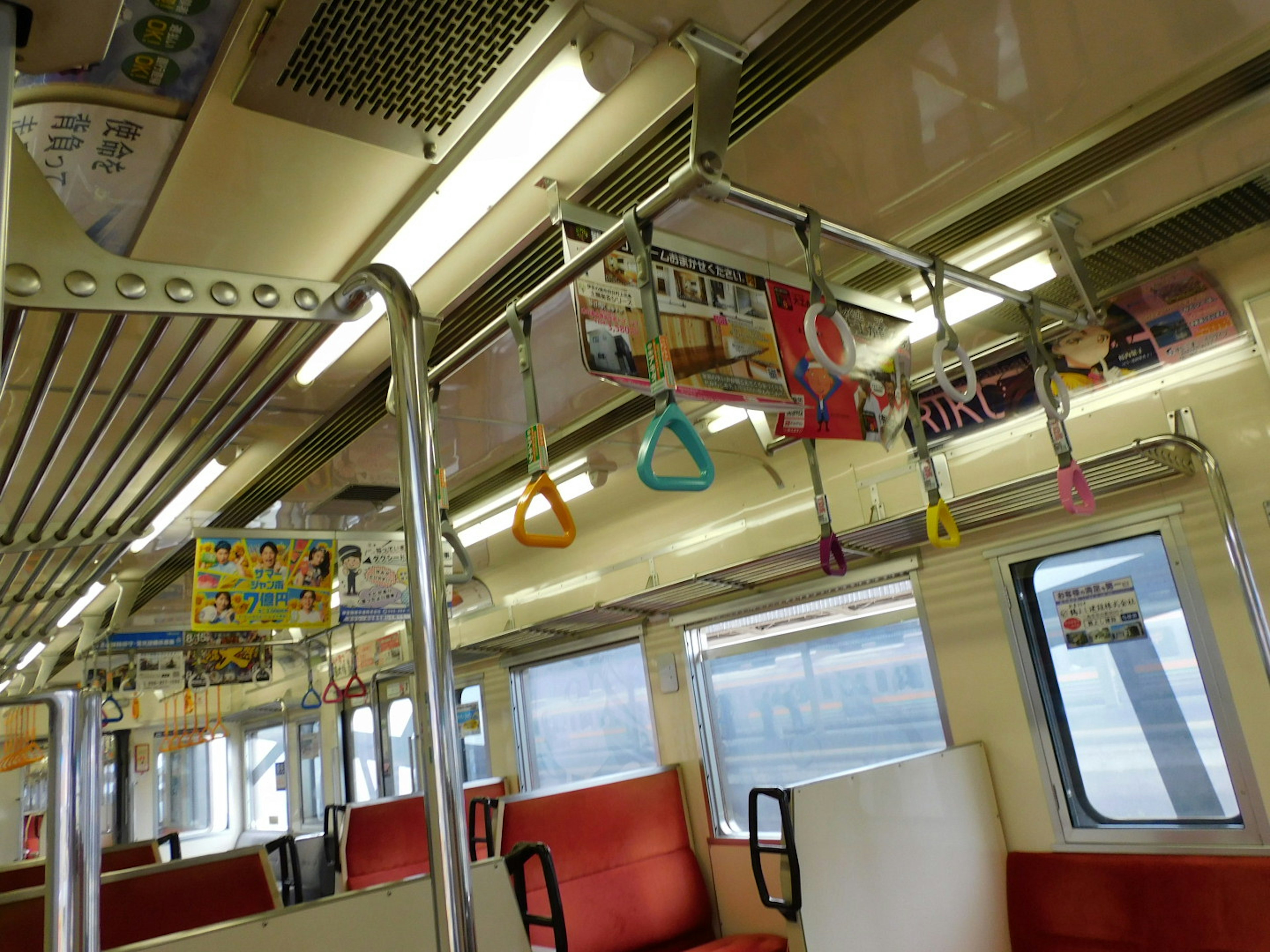 Interior of a nearly empty train car featuring orange seats