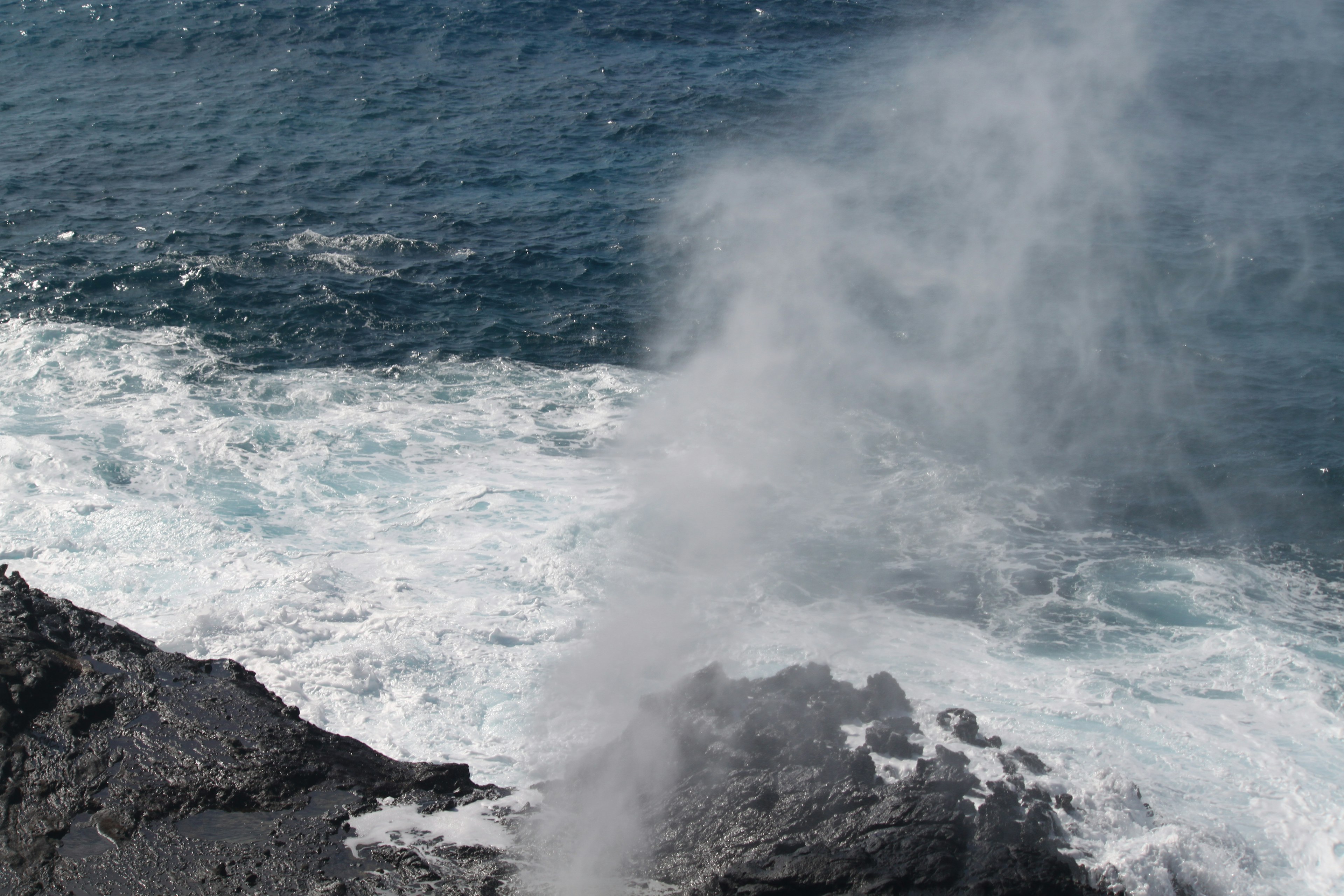 Seascape featuring waves and a geyser-like spray from rocks