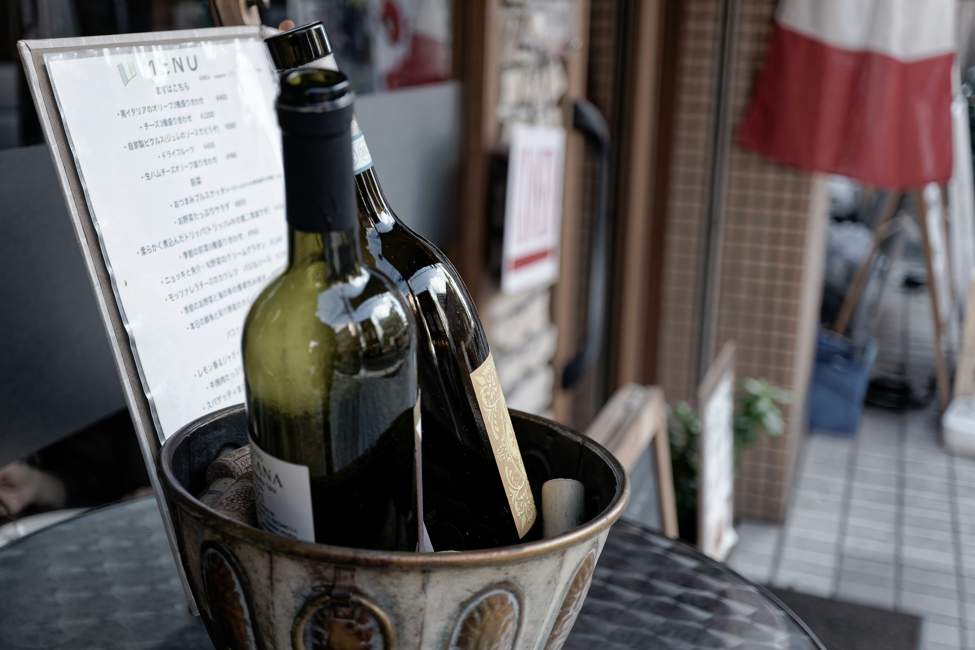 Botellas de vino en un cubo junto a un menú en una mesa