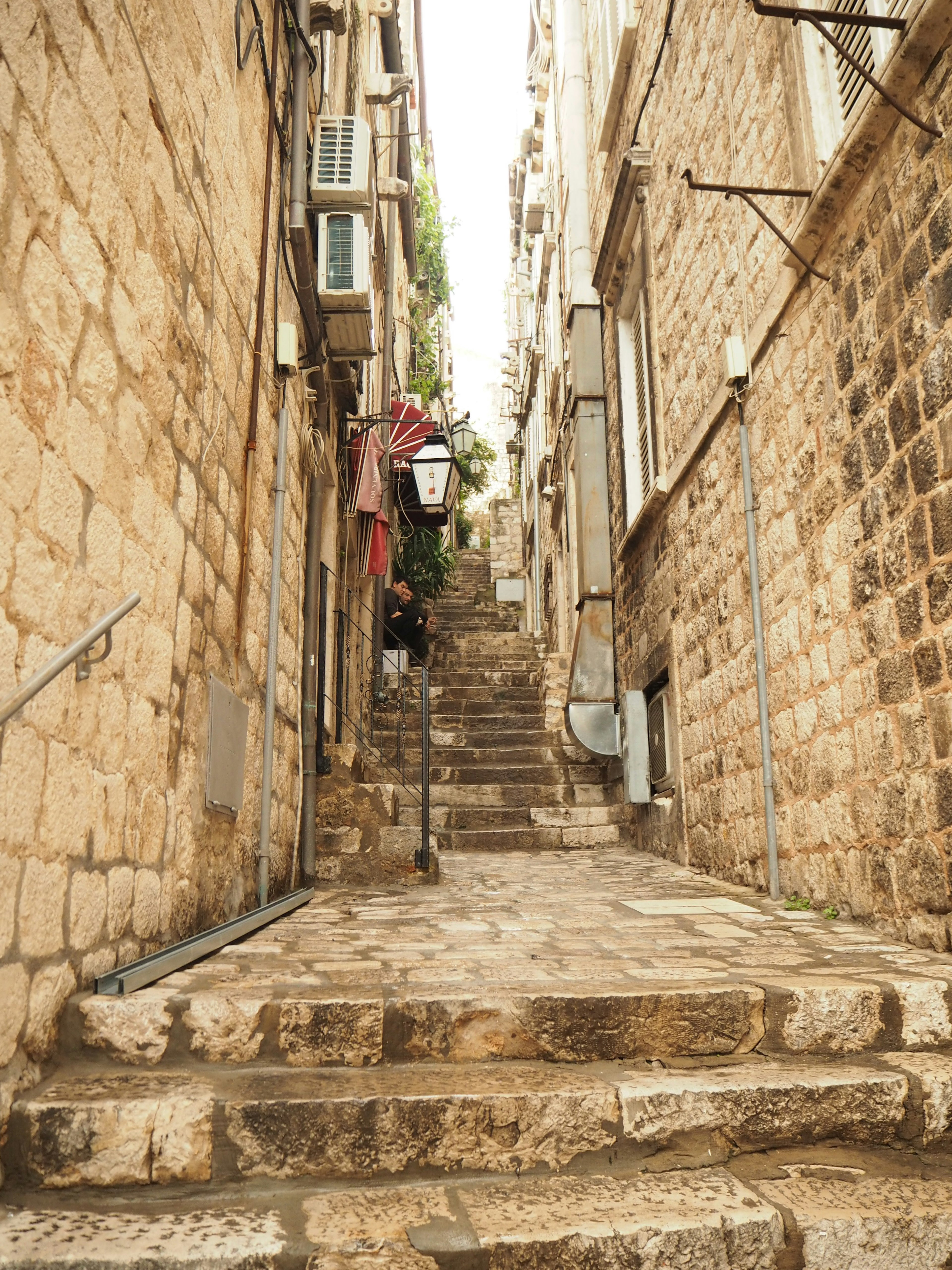 Narrow alley in stone with stairs and old buildings