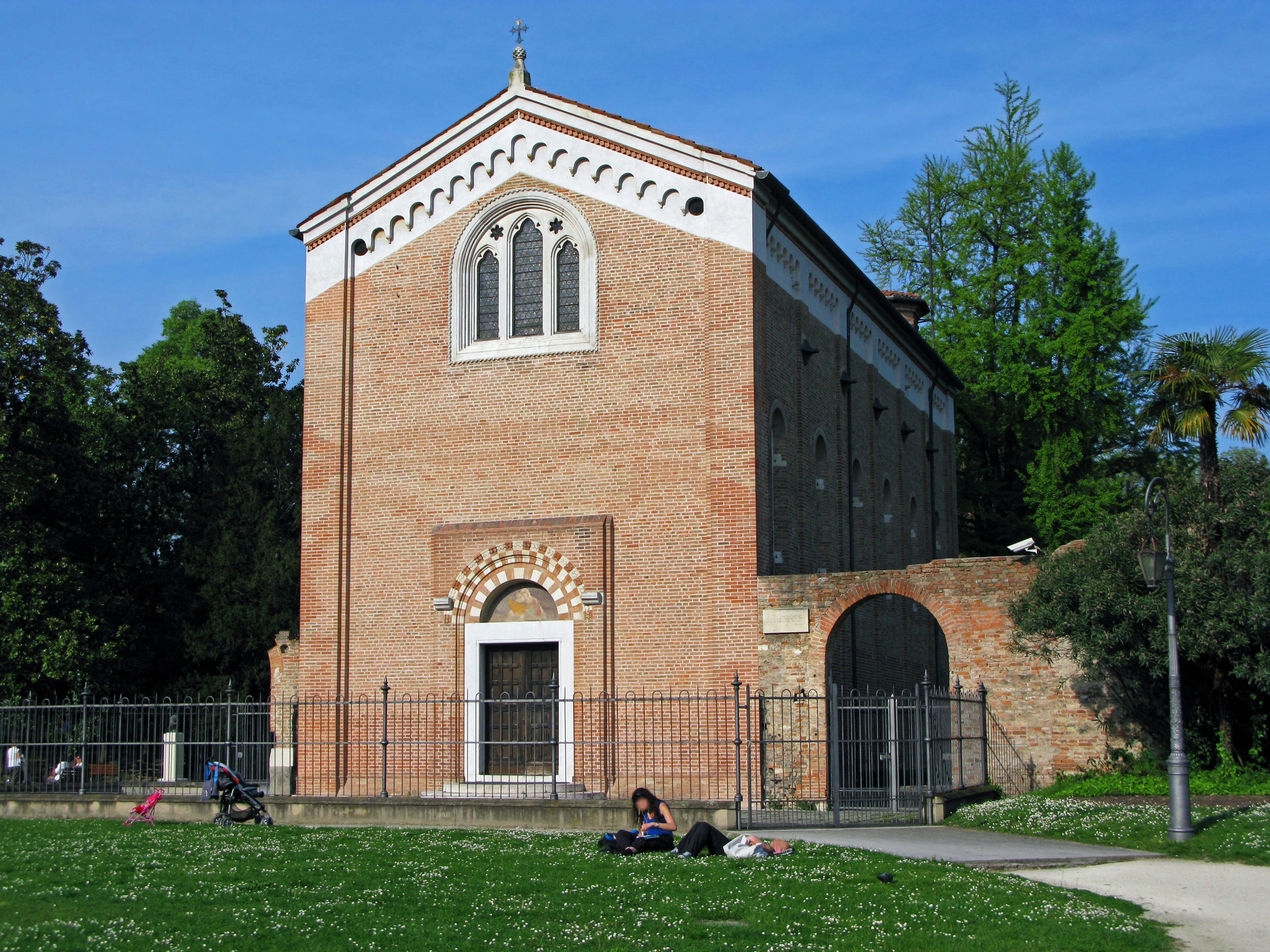 Bâtiment en briques avec un style architectural distinctif entouré d'herbe verte