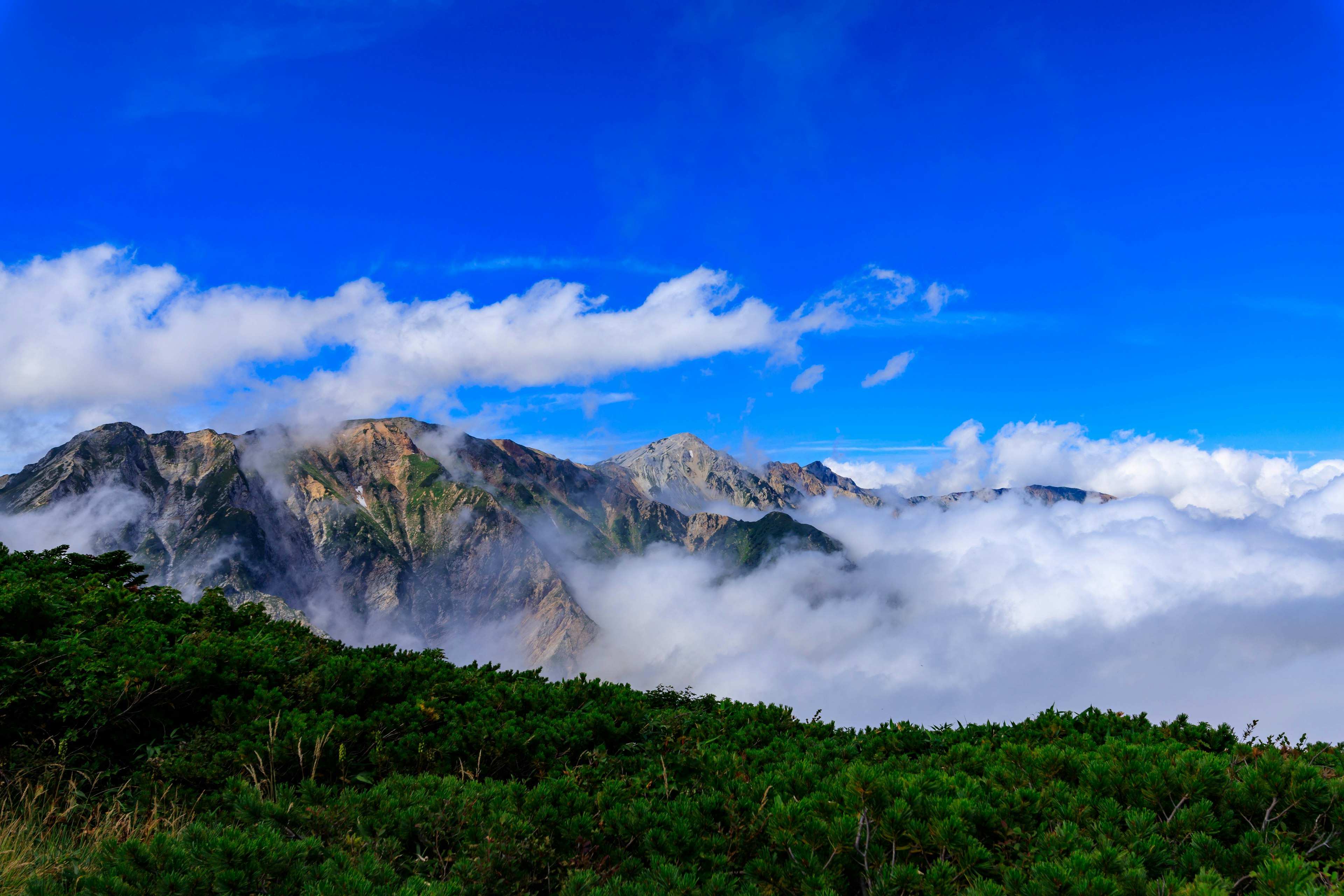 Vue panoramique de montagnes sous un ciel bleu et des nuages